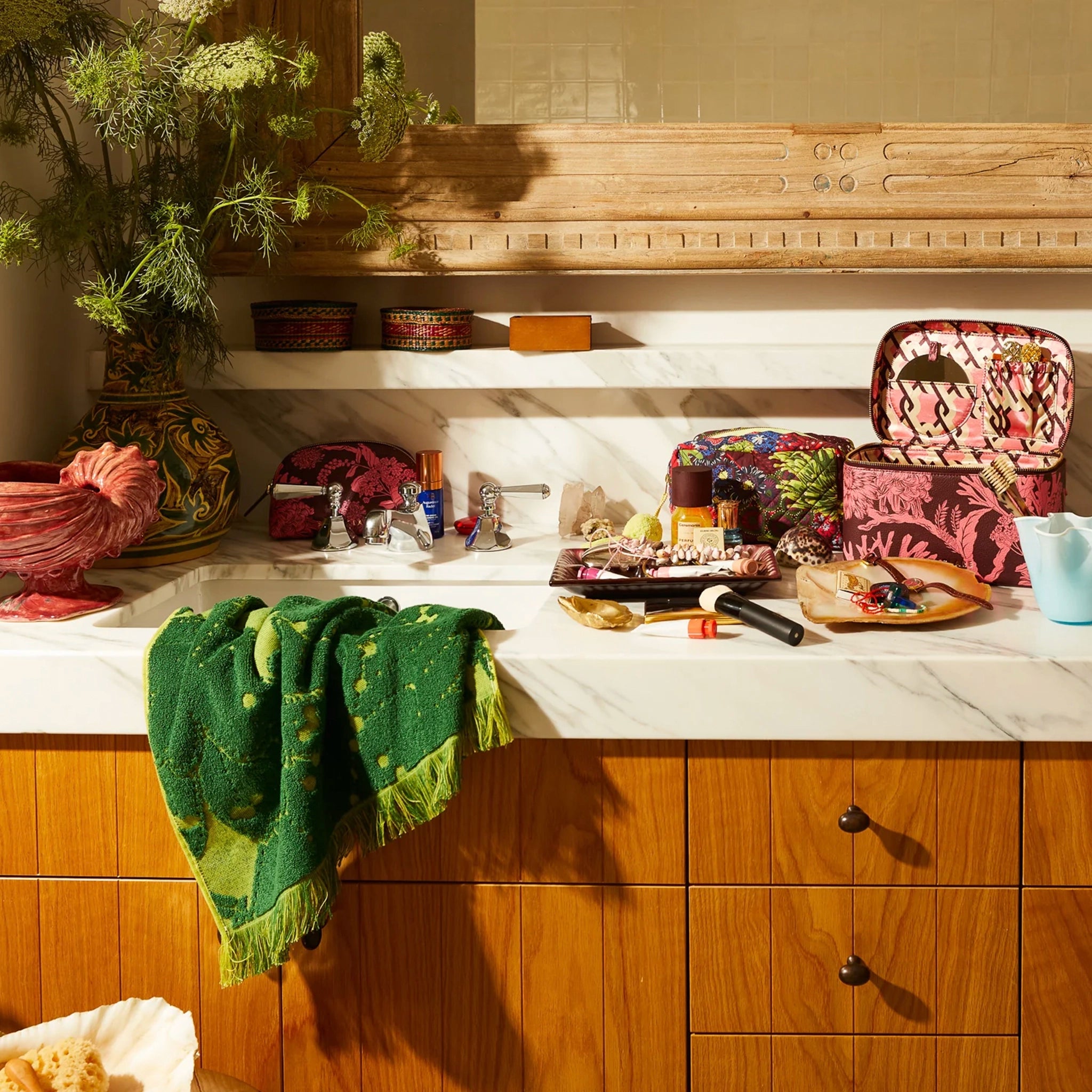 Kitchen counter with various items including a green towel, pink bags, and decorative objects.