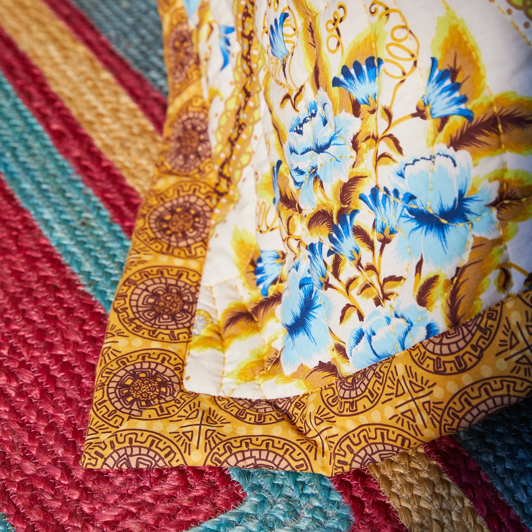 Close-up of a fabric with blue floral pattern on a textured multicolored surface