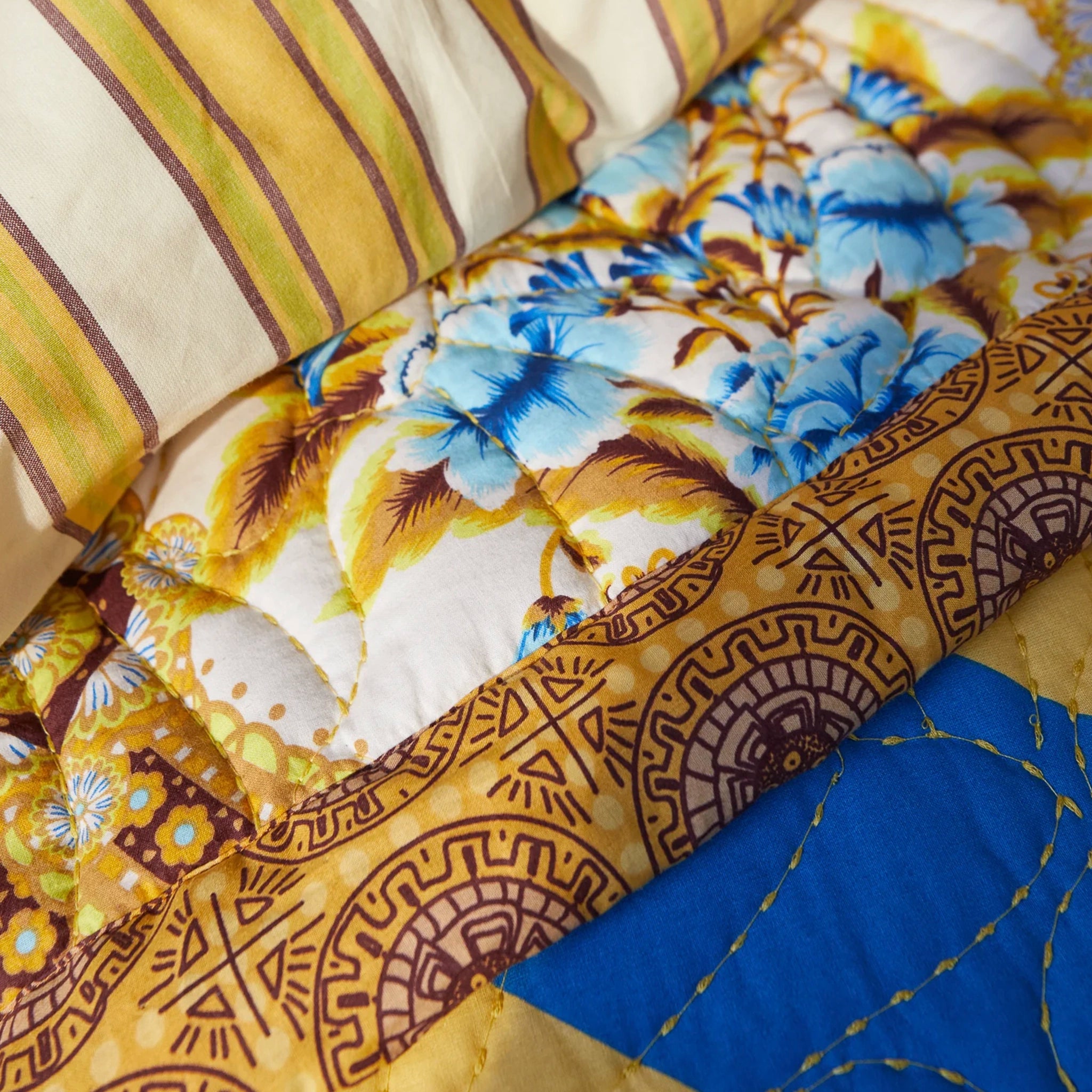 Close-up of a quilt with various patterns including floral and geometric designs.