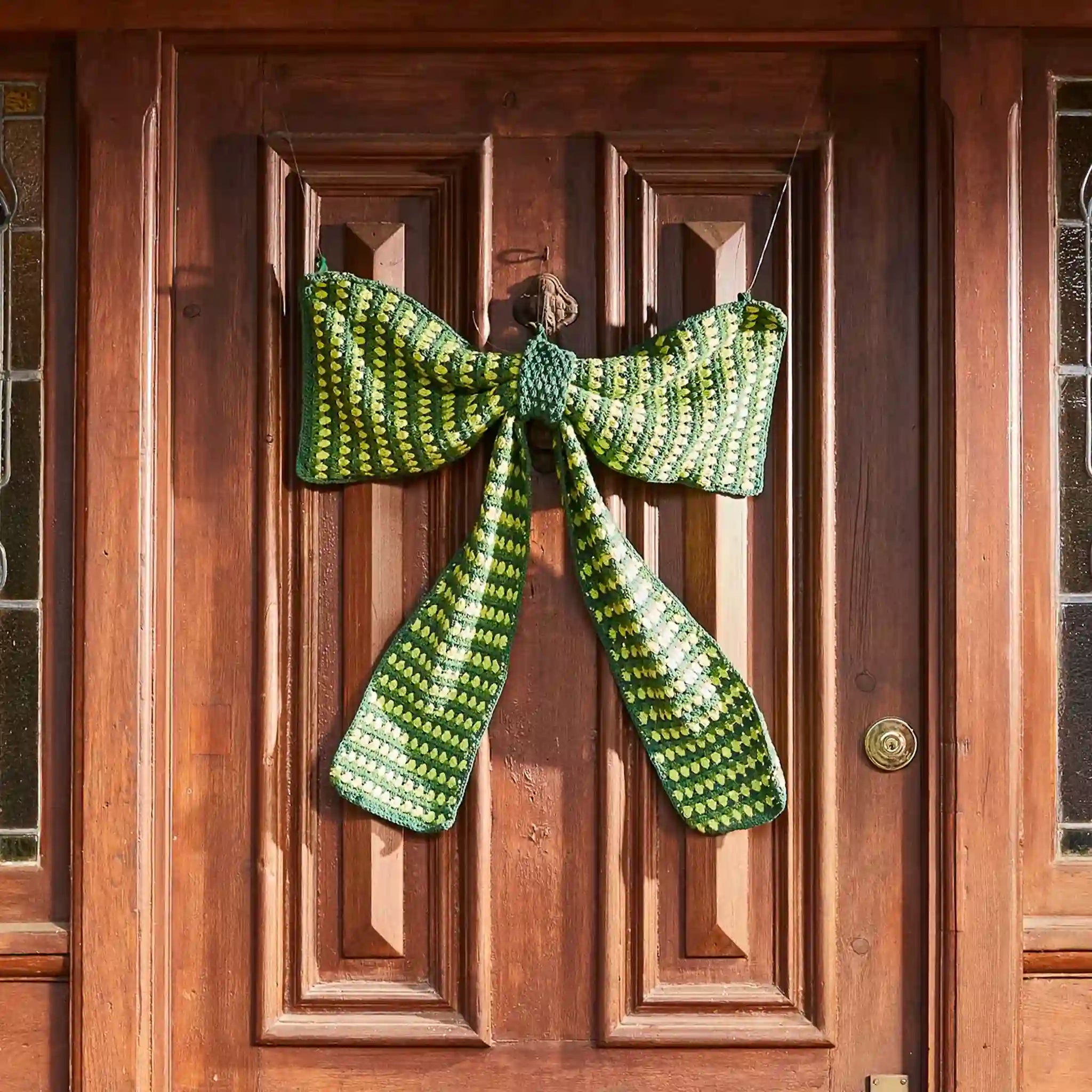 Green knitted bow decoration on a wooden door