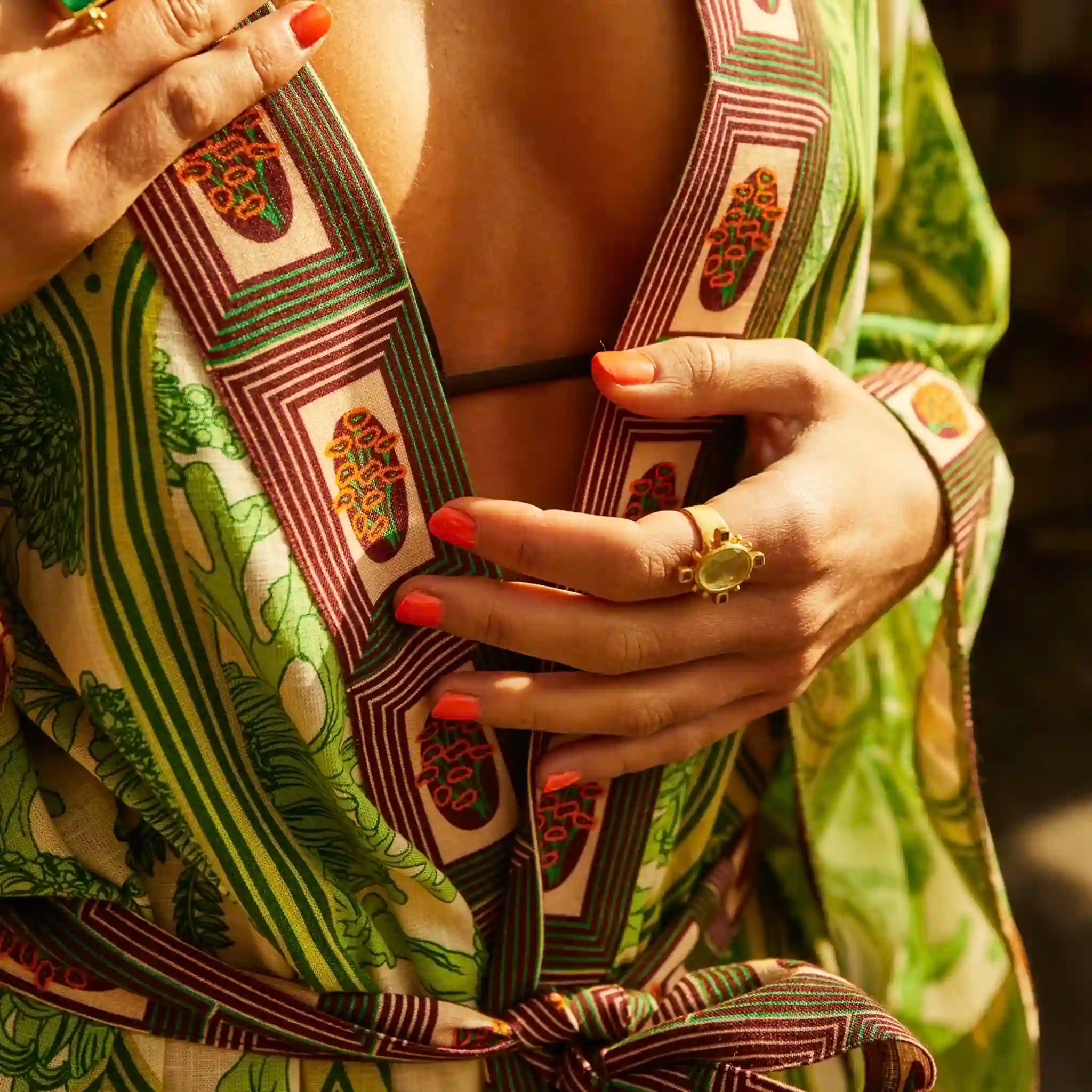 Close-up of a person wearing a patterned garment with a focus on the fabric and hands.