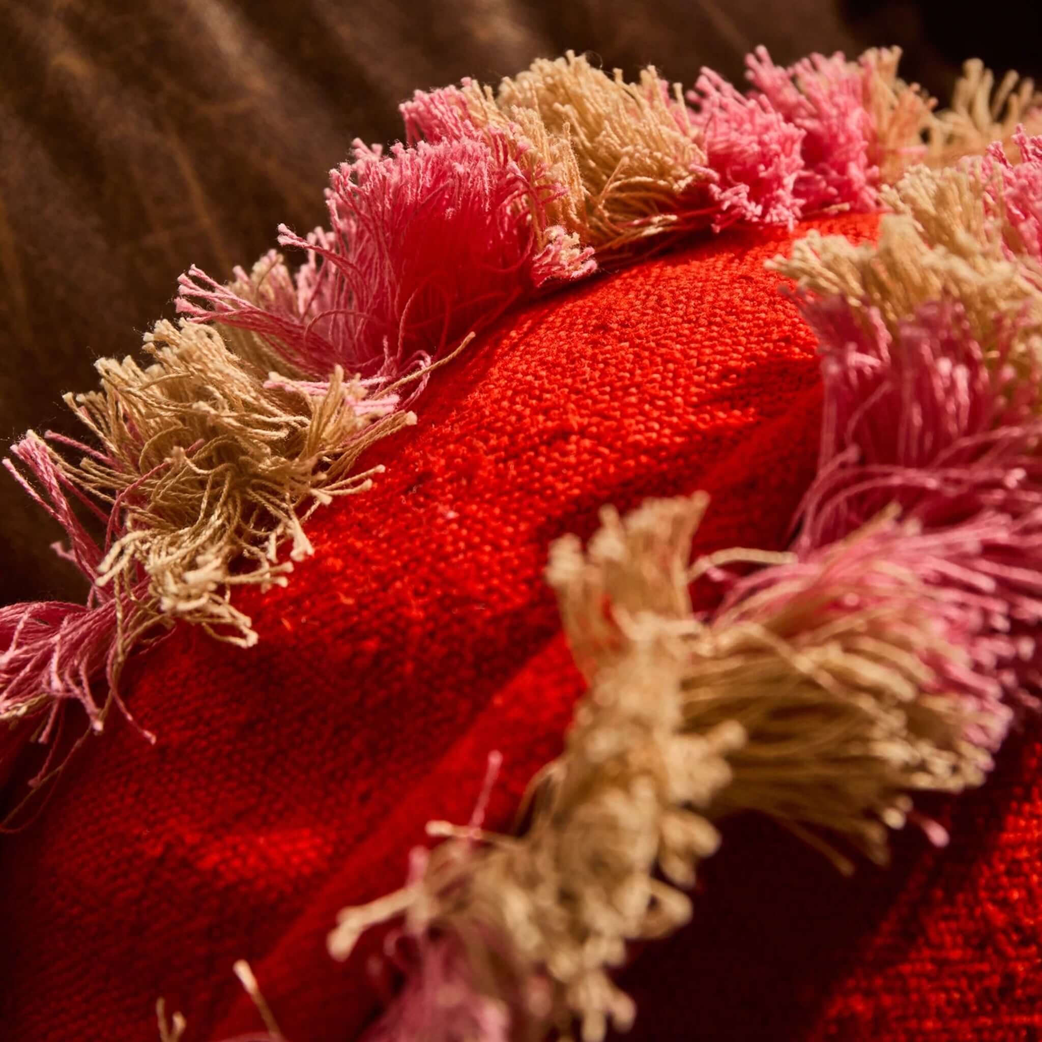 Sage x Clare Reese Round Cushion - Poppy featuring textured poppy-red fabric and playful pink and sand fringe detailing.