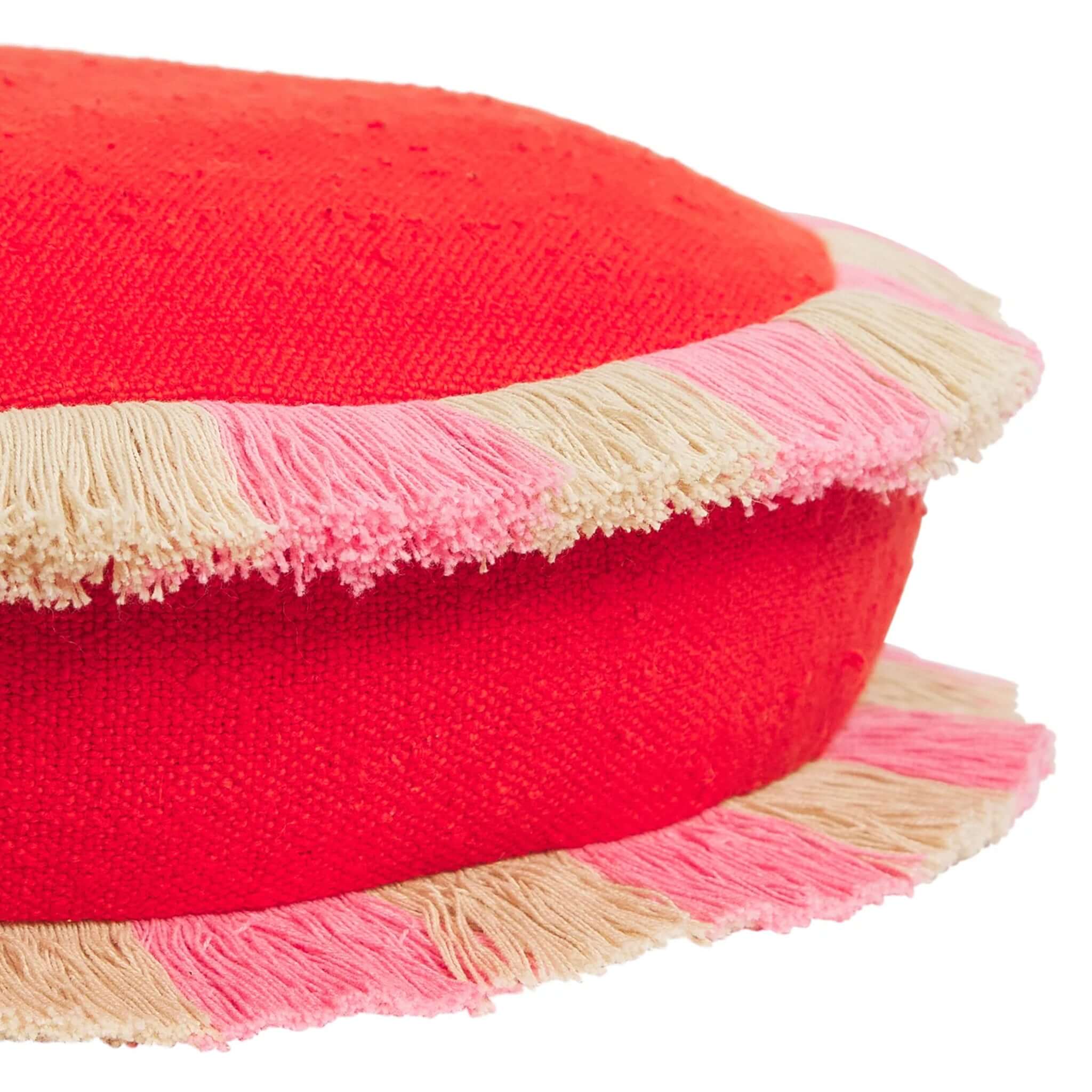 Sage x Clare Reese Round Cushion - Poppy with textured poppy-red fabric and playful fringe in pink and sand.