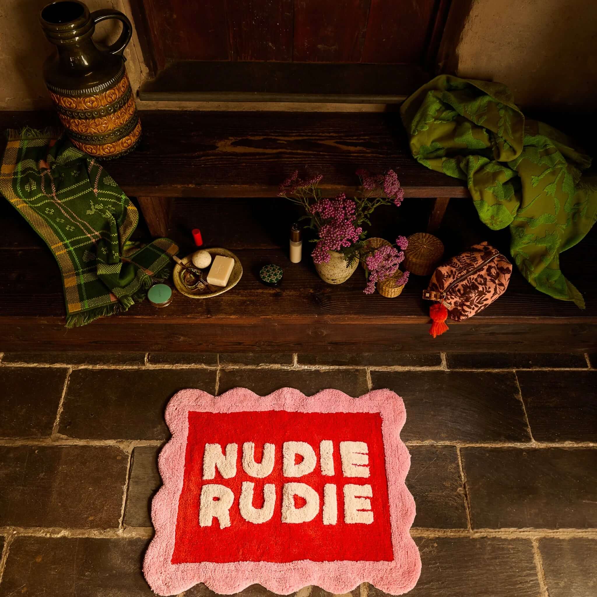 Sage x Clare Romy Nudie Bath Mat - Poppy with 'Nudie Rudie' lettering on a red background