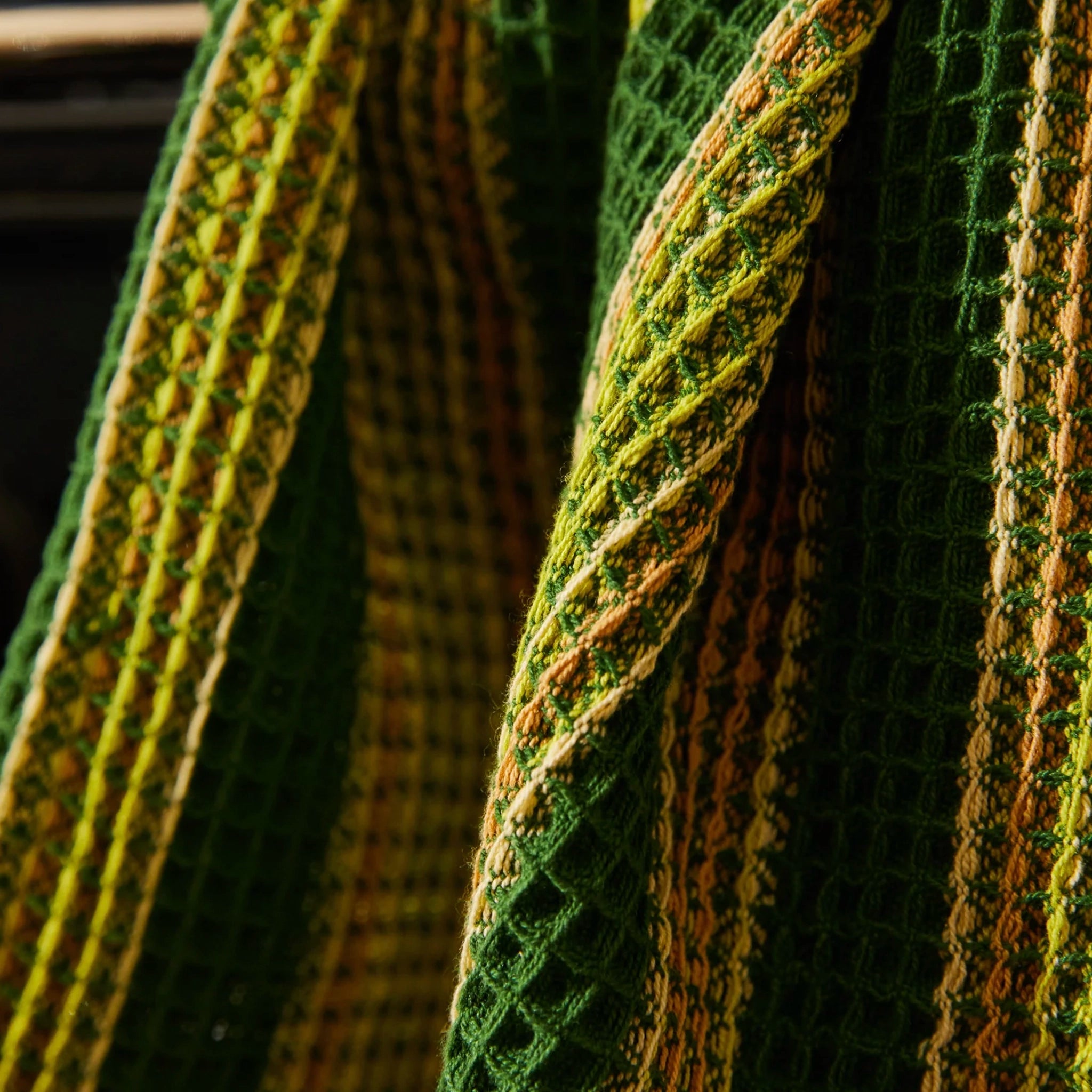 Close-up of green and brown textured tea towel with a woven pattern.