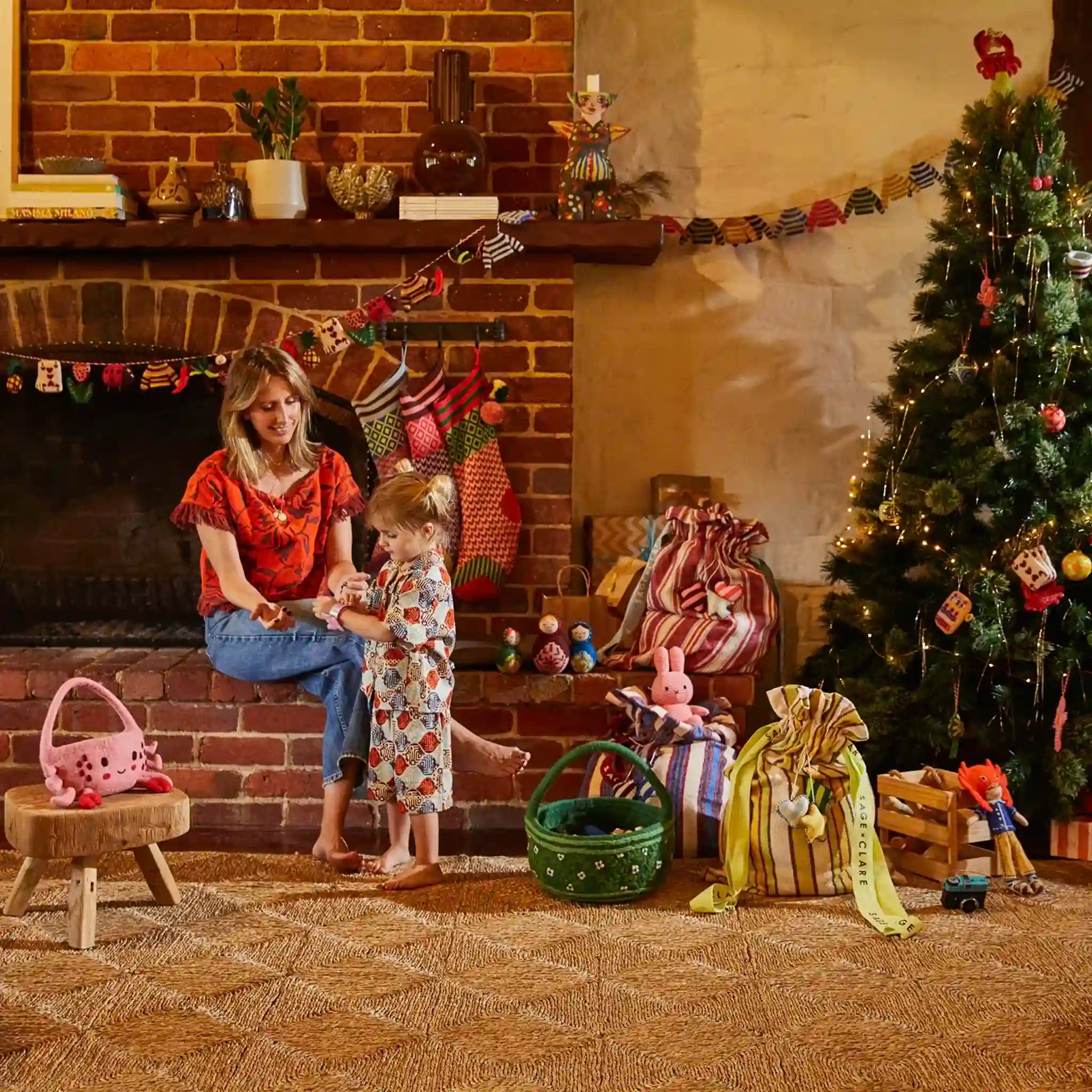 Woman and child in a festive living room with Christmas decorations.