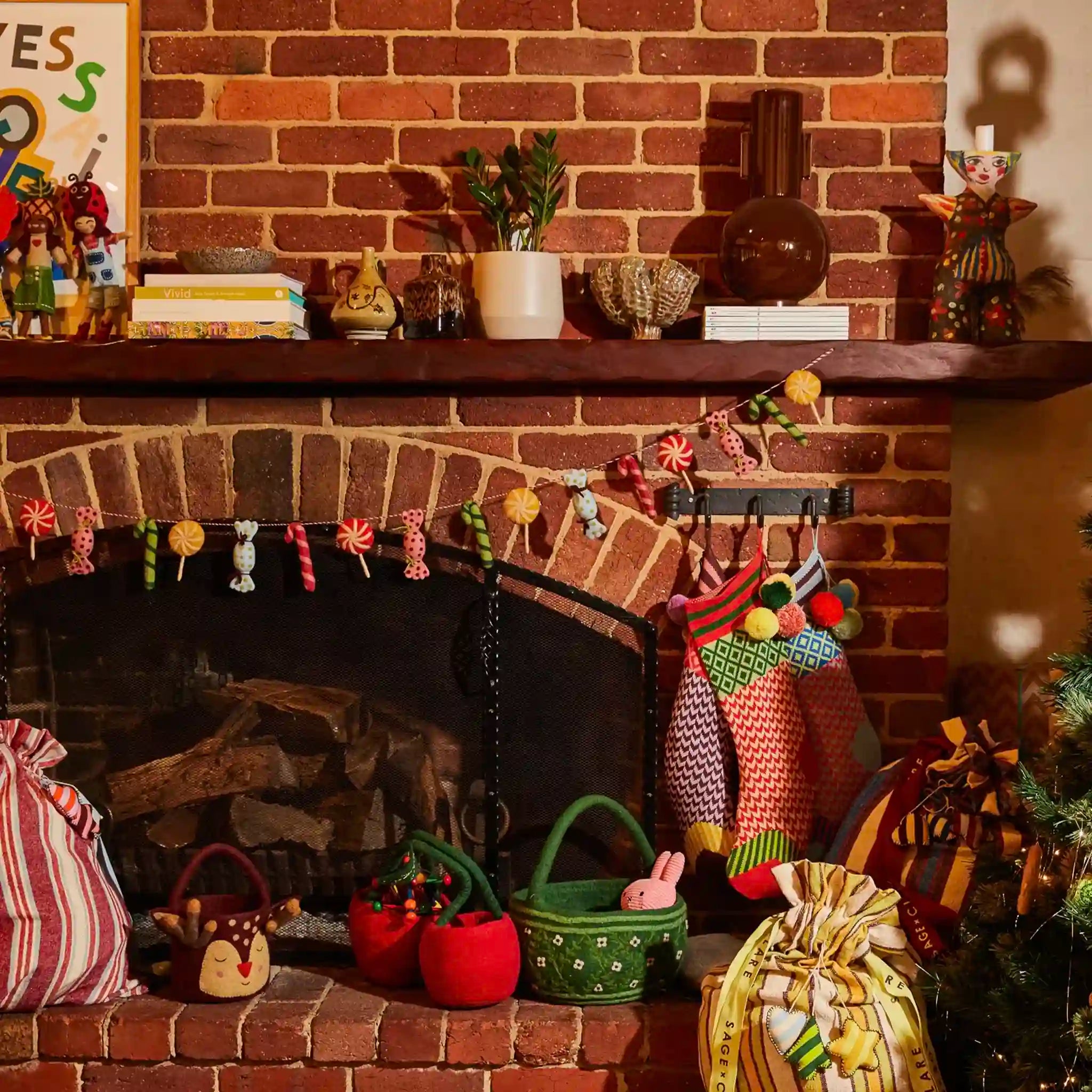 Decorative fireplace with stockings, baskets, and a sign on a brick wall.