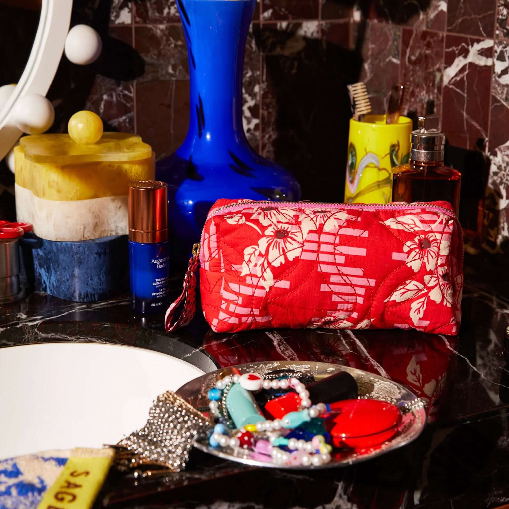 Alt Tag: Sage x Clare Travel Pouch - Marta Vermillion red quilted cotton travel pouch on bathroom vanity for makeup, skincare and essentials