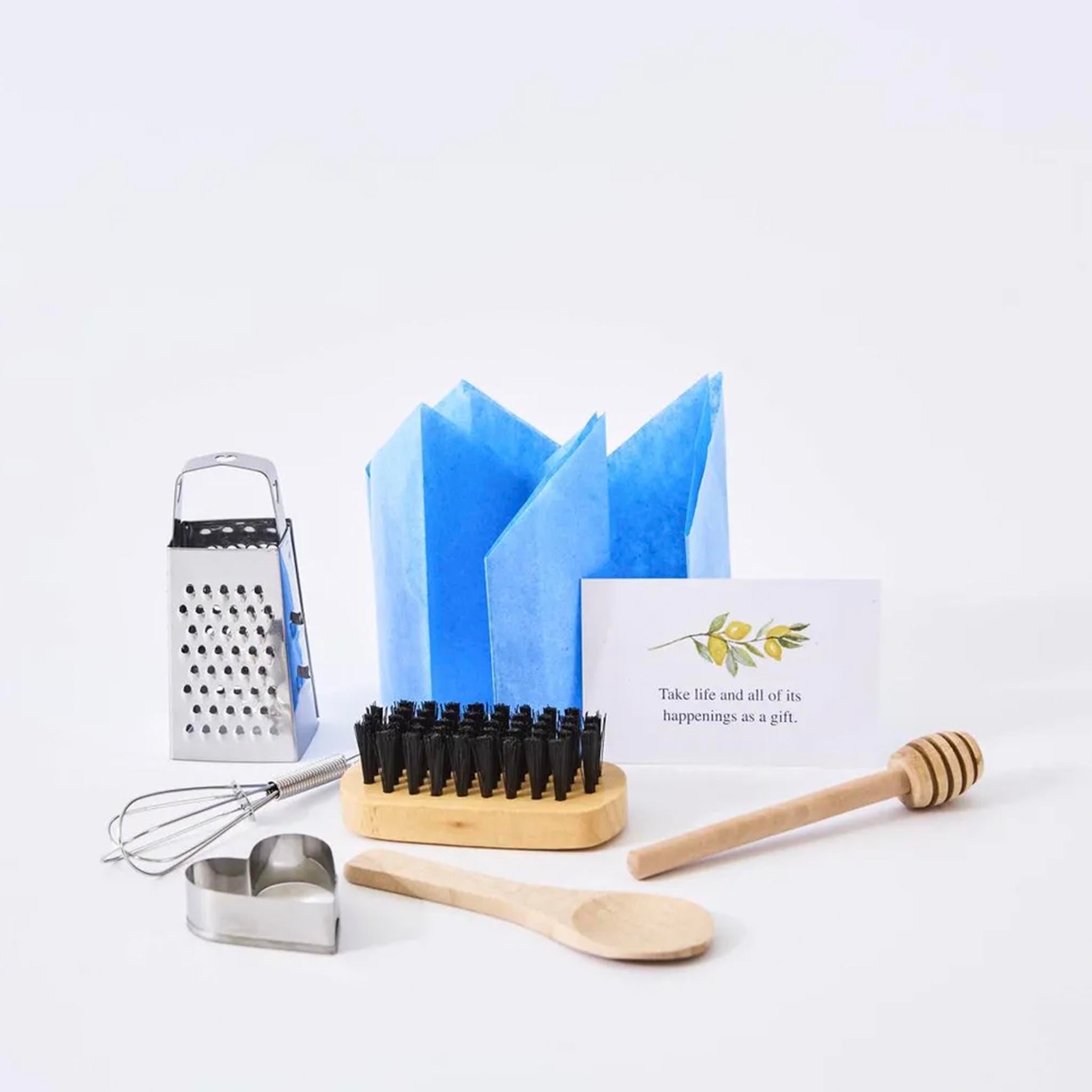 Set of kitchen utensils including a grater, whisk, cookie cutter, brush, spoon, and honey dipper on a white background.