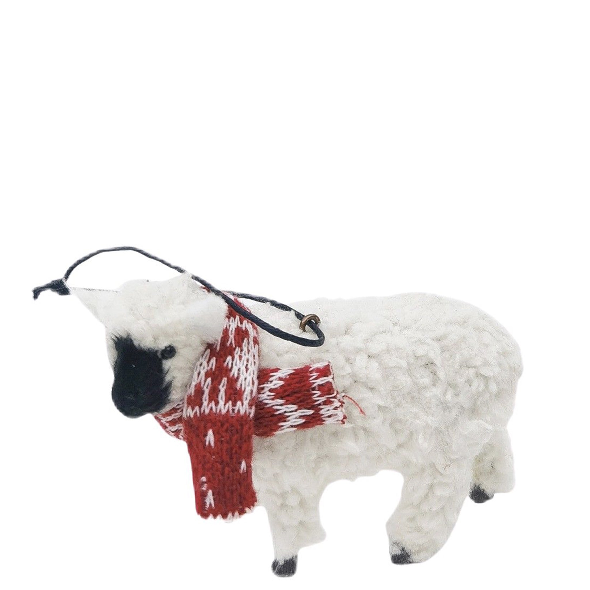 Decorative sheep ornament with a red and white scarf on a white background