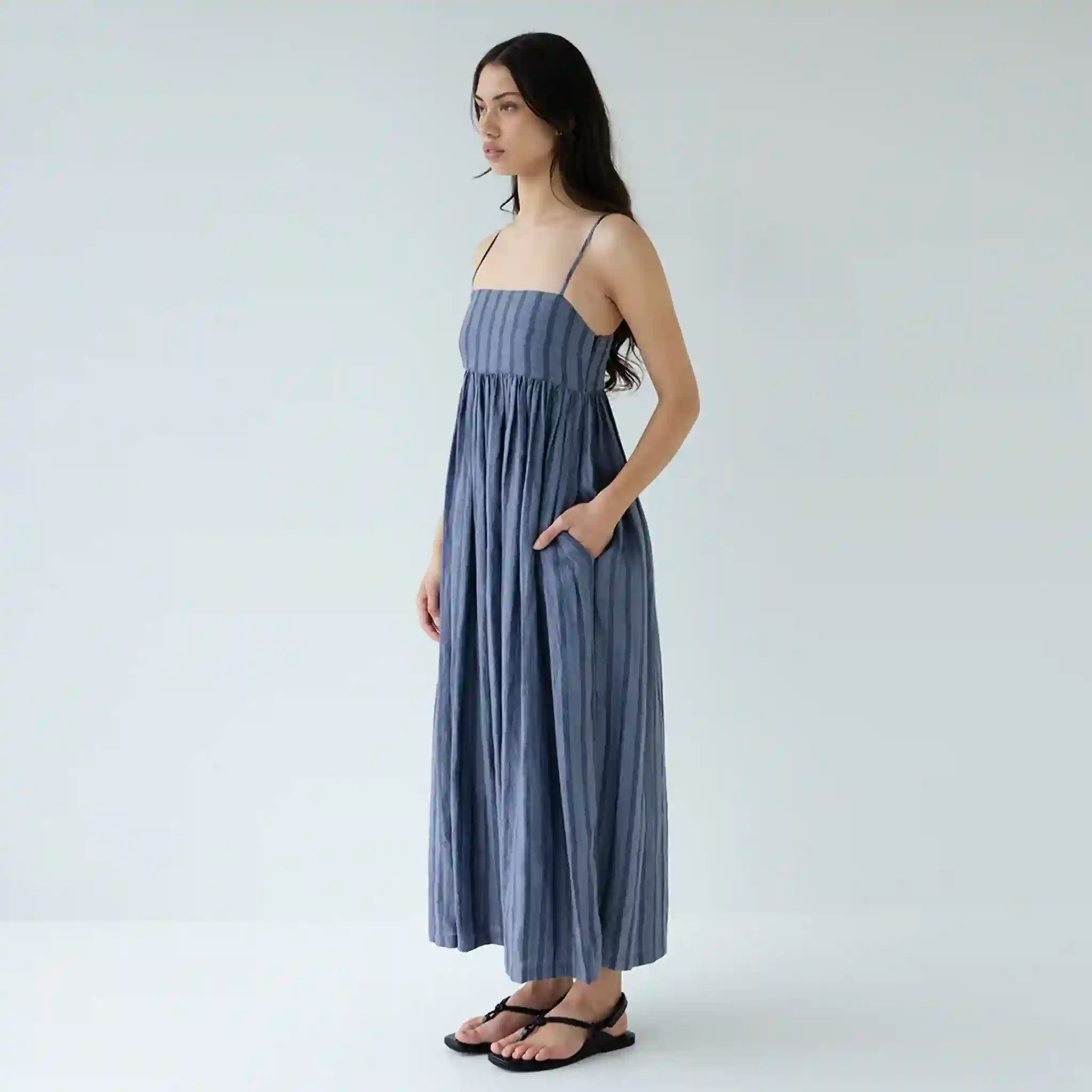 Woman wearing a blue striped dress on a white background