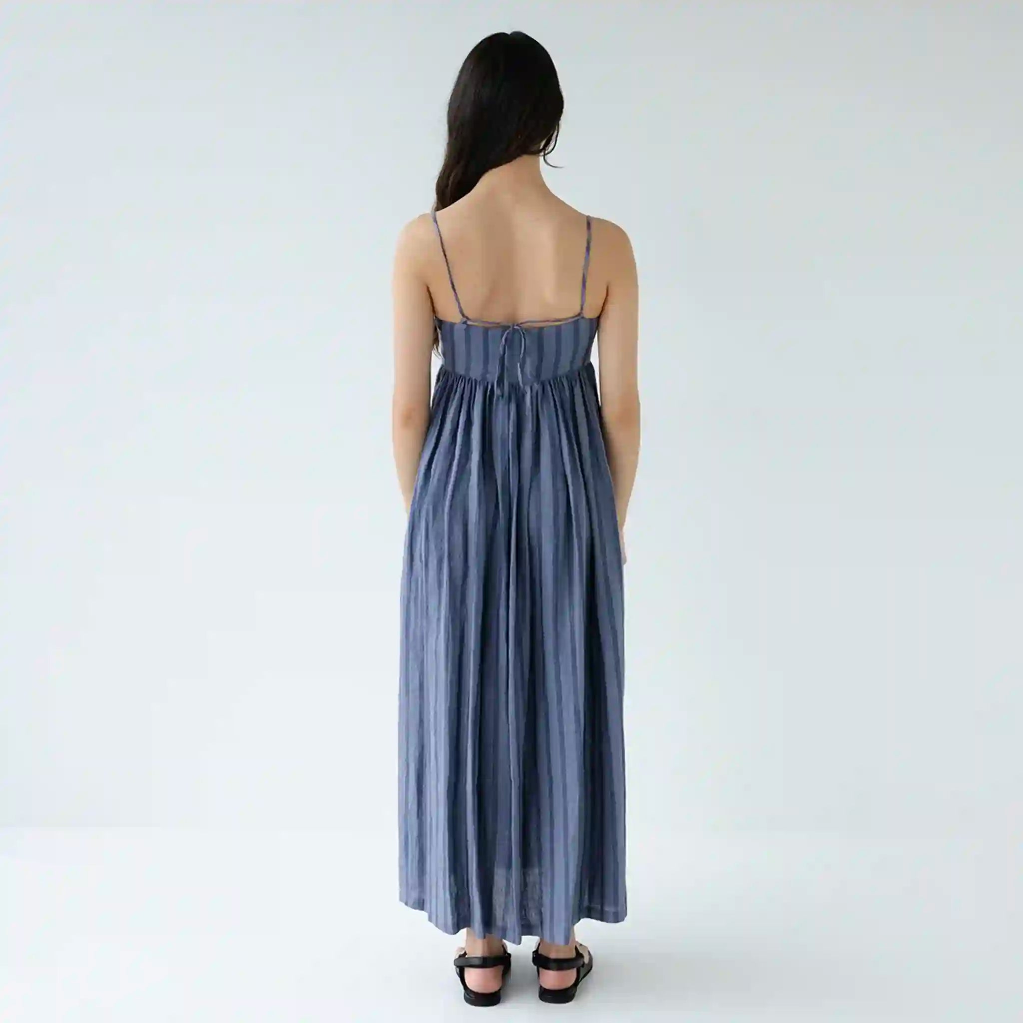 Woman wearing a blue striped dress on a white background