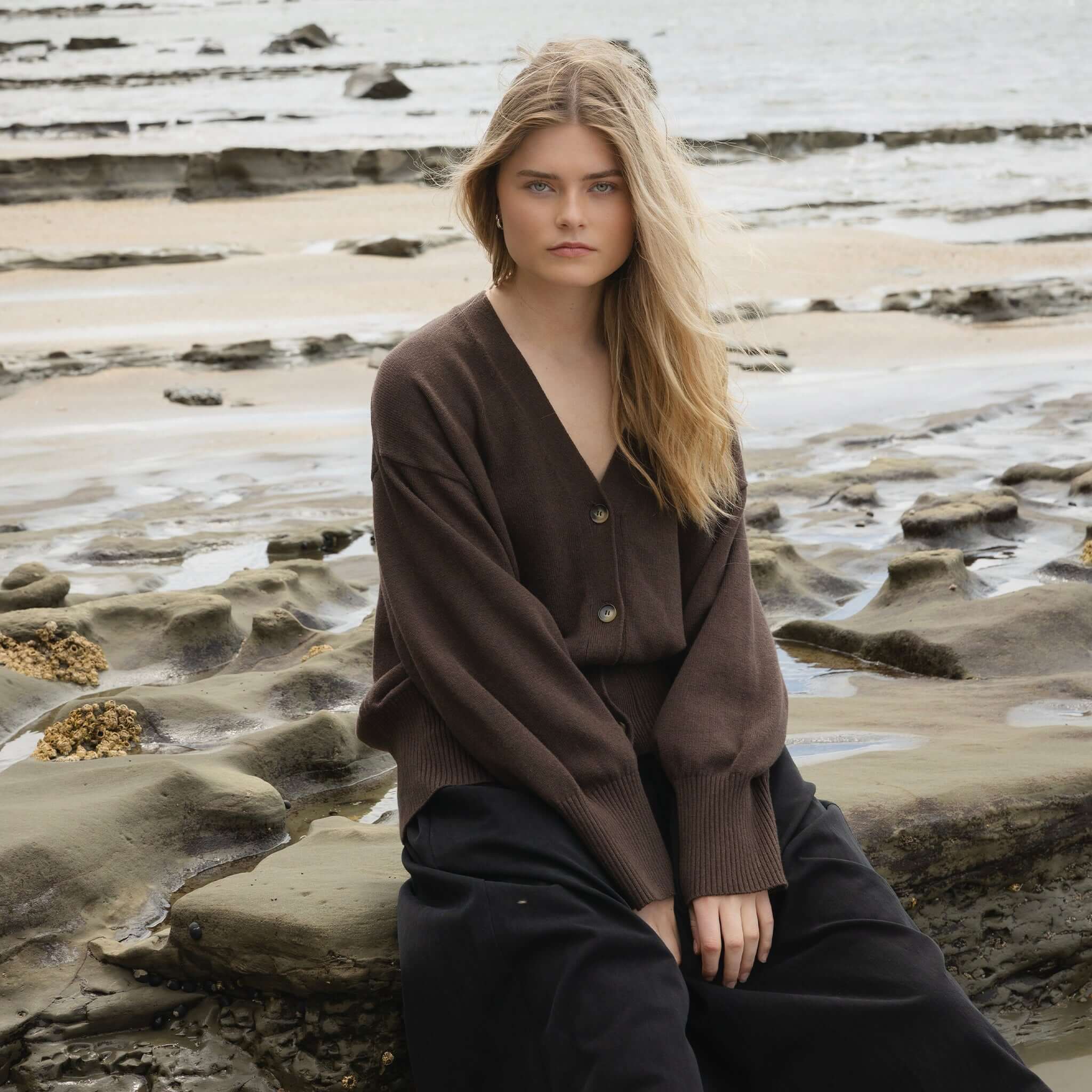 Alt Tag: Sophie Love Me Cotton & Cashmere Cardigan - Cocoa worn by model on rocky beach, relaxed oversized fit cotton-cashmere layer