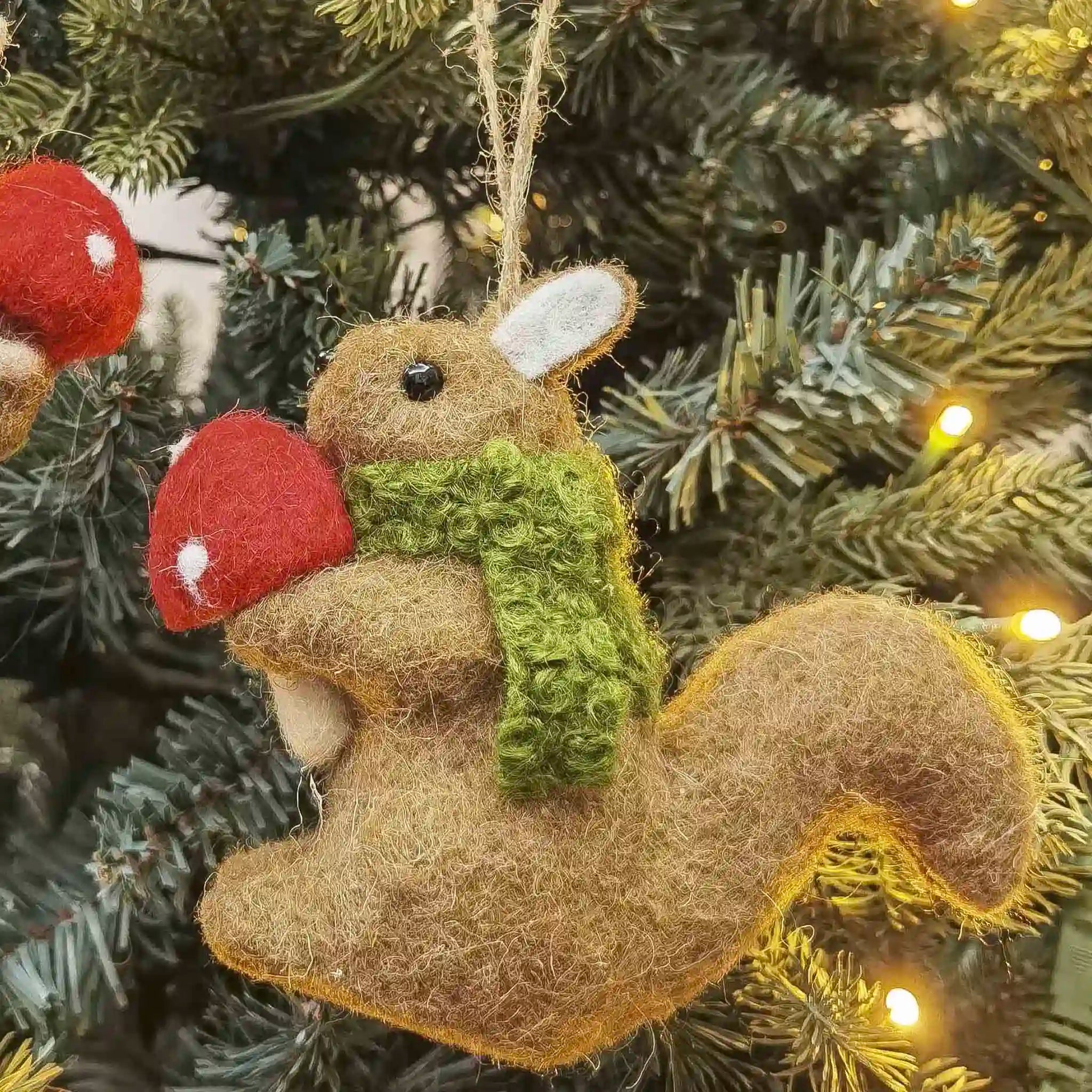 Squirrel ornament with red mushroom on a Christmas tree