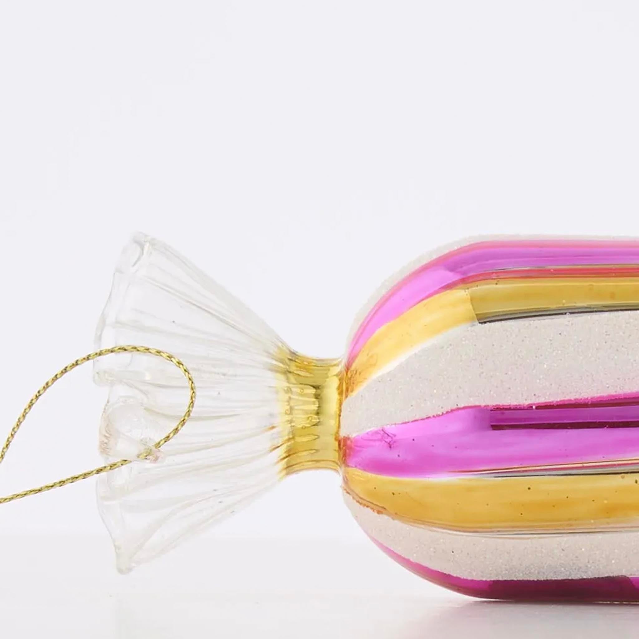 Decorative candy-shaped ornament with pink and gold stripes on a white background