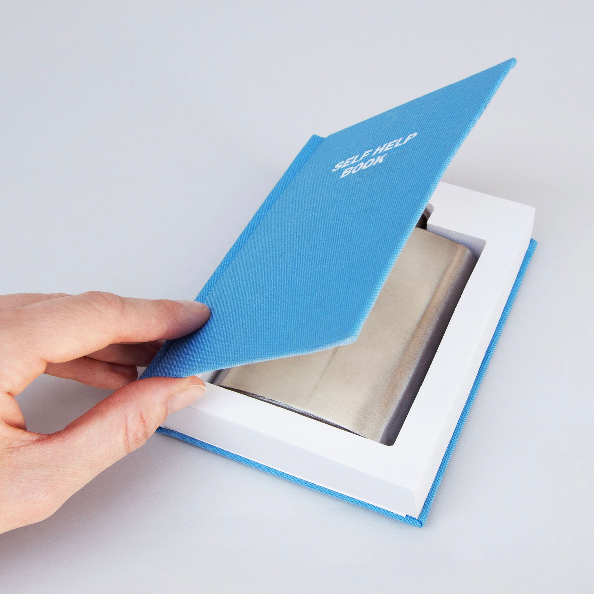 A hip flask in a self help book.