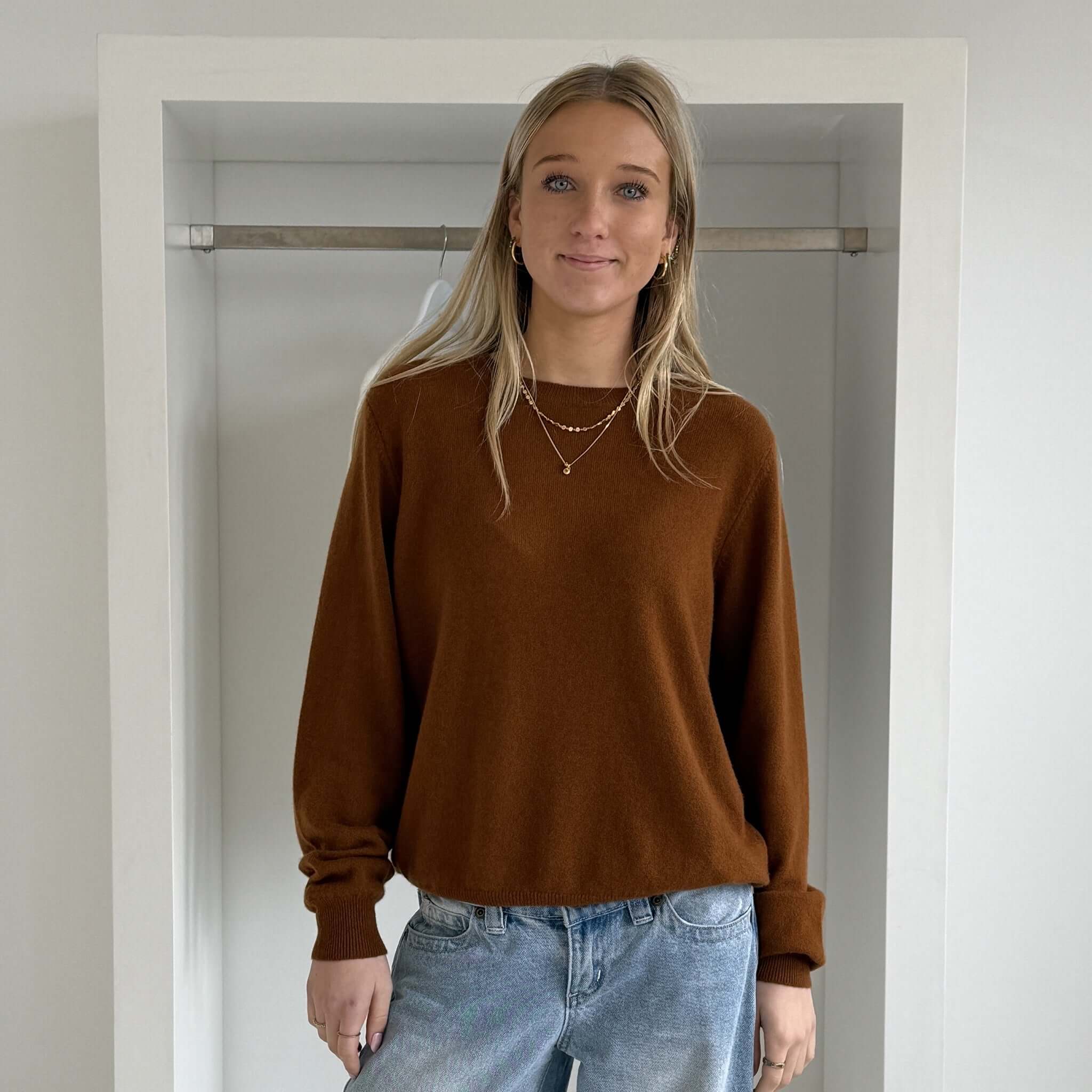 The Uniform Cashmere Crew Neck Sweater - Saddle worn by a model with relaxed fit and ribbed details.