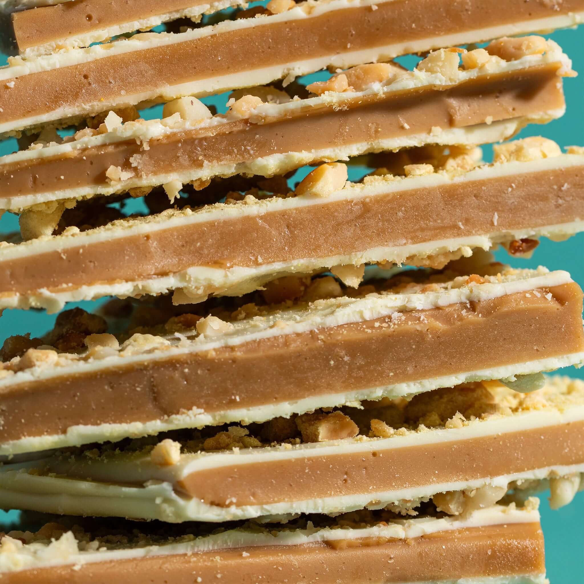 The Confectionist Limited Edition White Chocolate, Macadamia & Lemon Toffee - Large stacked pieces of toffee.