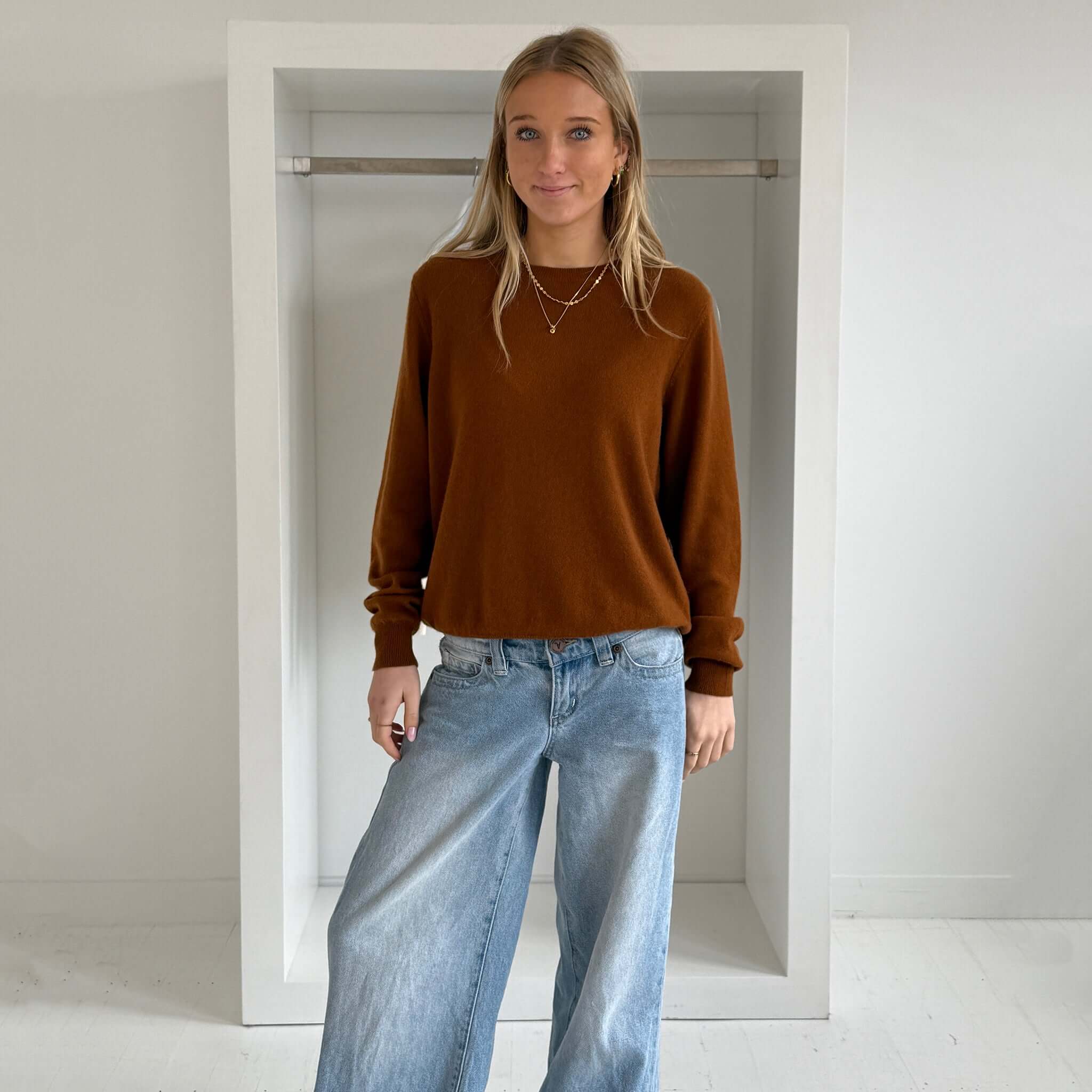 The Uniform Cashmere Crew Neck Sweater - Saddle worn by a model in a minimalist setting with relaxed jeans.