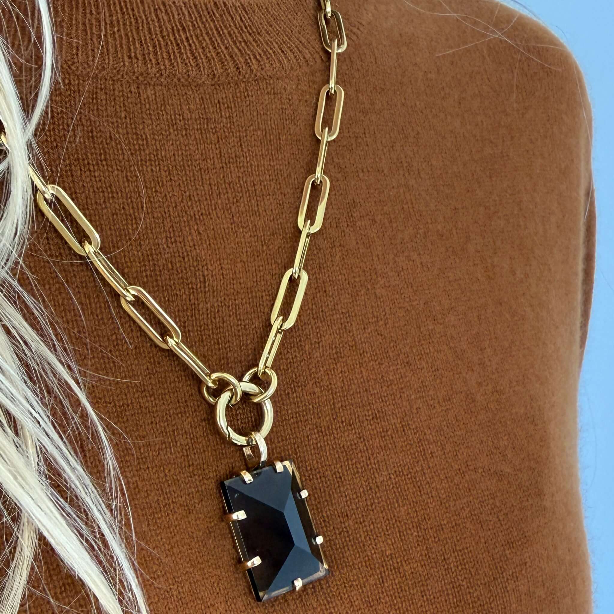The Uniform Cashmere Crew Neck Sweater - Saddle with gold chain necklace featuring black gemstone pendant.