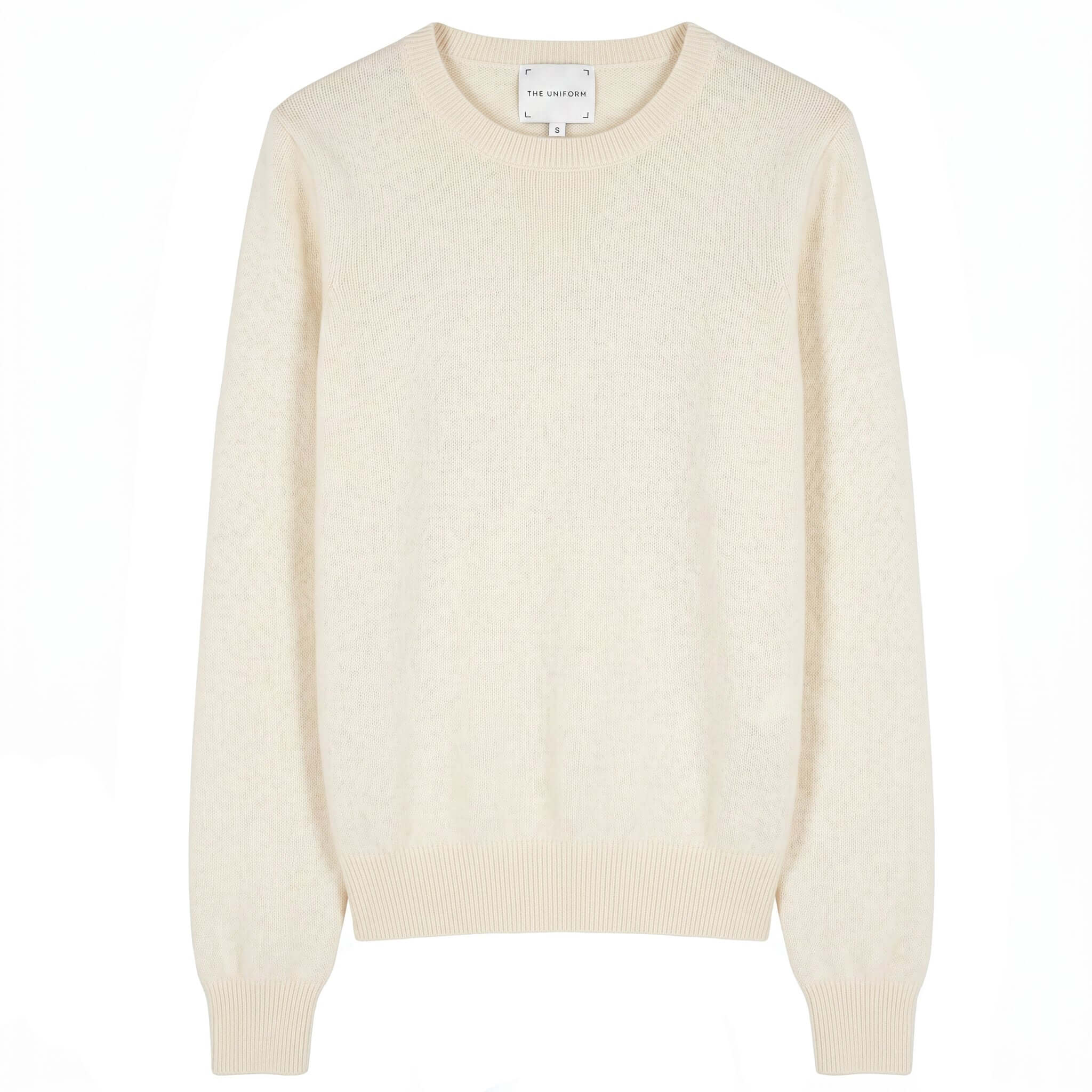 The Uniform Cashmere Crew Neck Sweater - Milk displayed in soft cream color with ribbed cuffs and neckline.