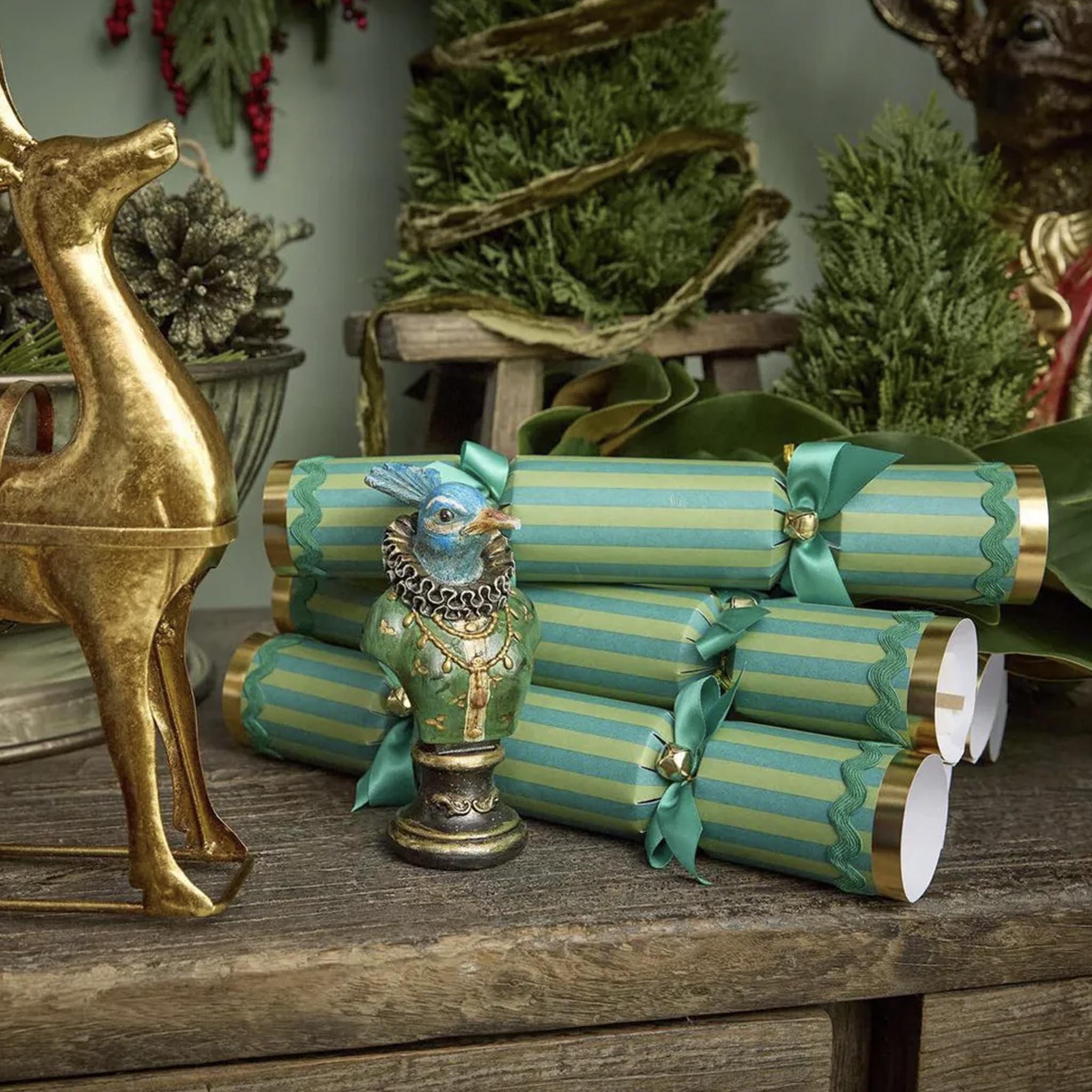 Decorative Christmas crackers with gold and green ribbons on a wooden table with festive decorations.
