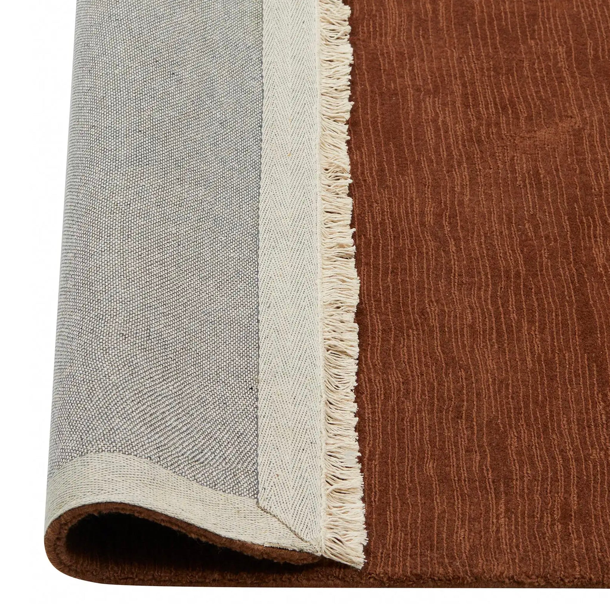 Close-up of a brown and gray rug with a fringed edge.