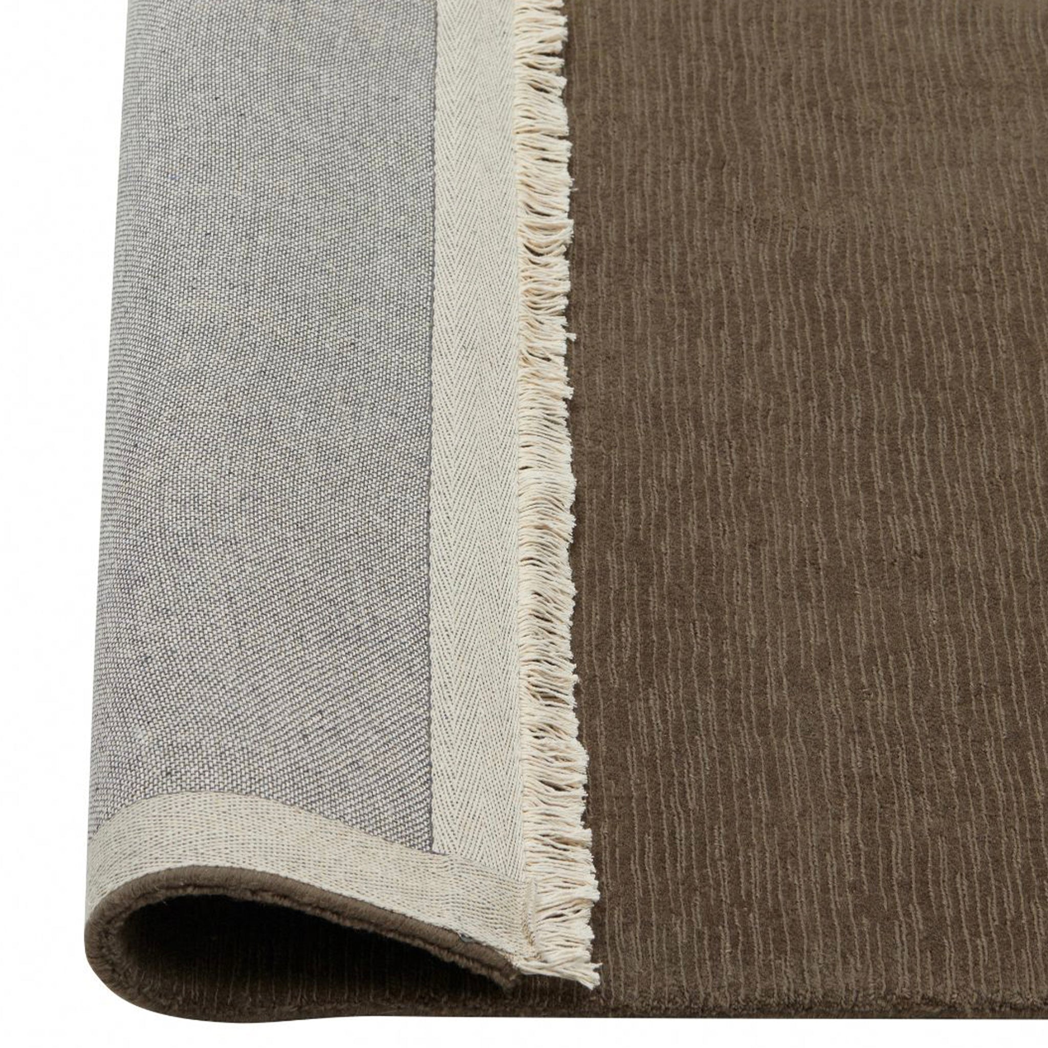 Close-up of a brown and gray rug with fringed edge