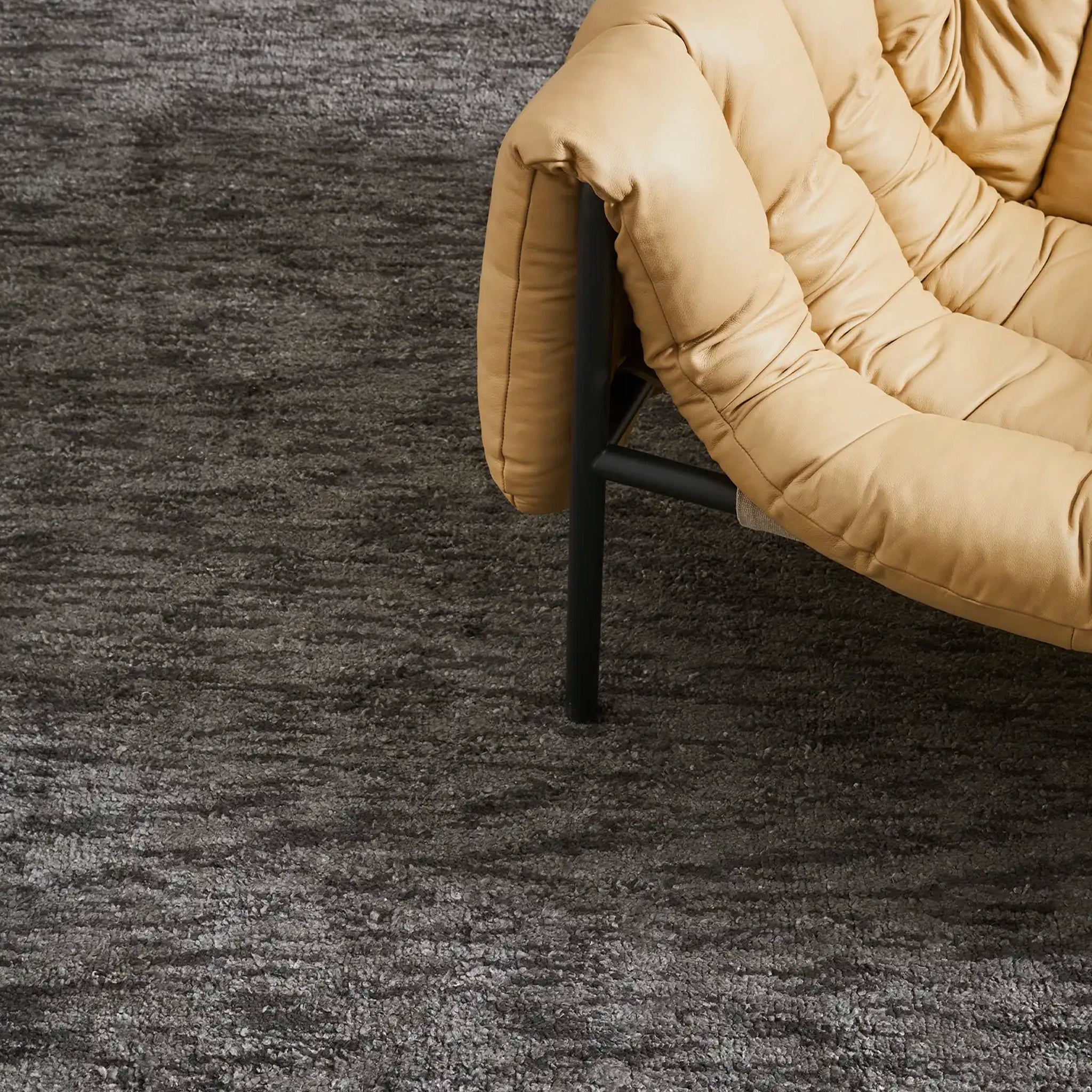 Beige cushioned chair on a dark textured carpet
