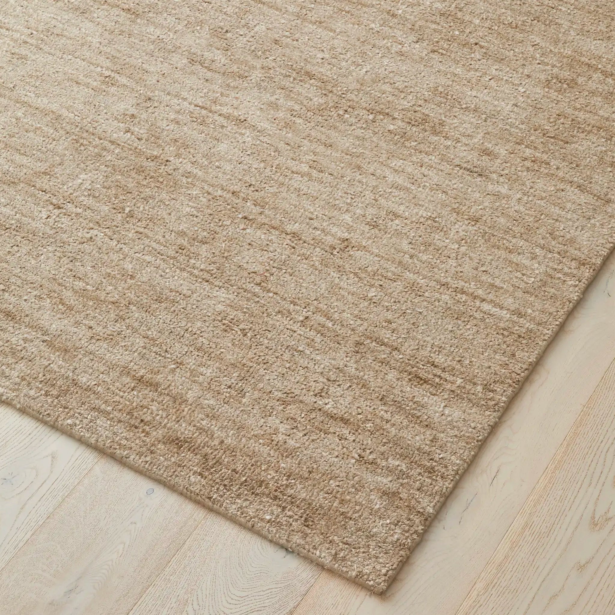 Beige rug on a light wooden floor