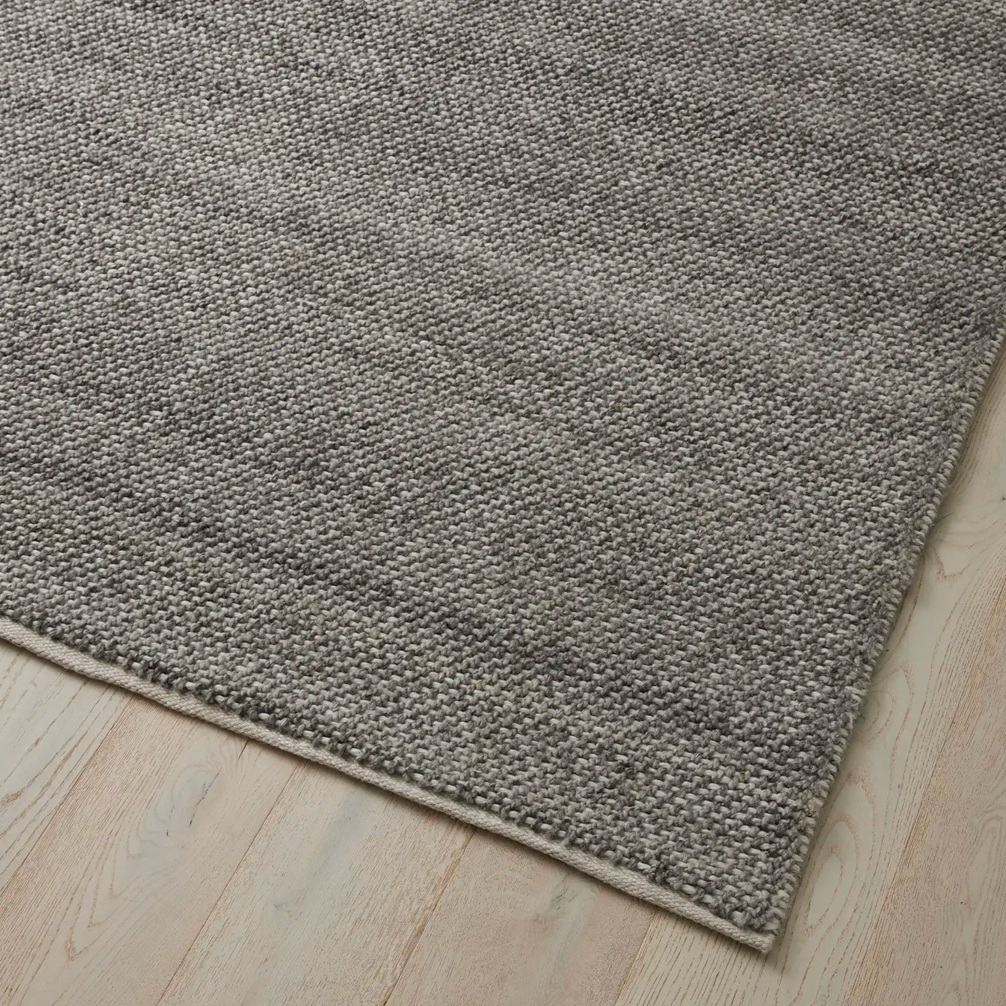 Gray textured rug on a wooden floor