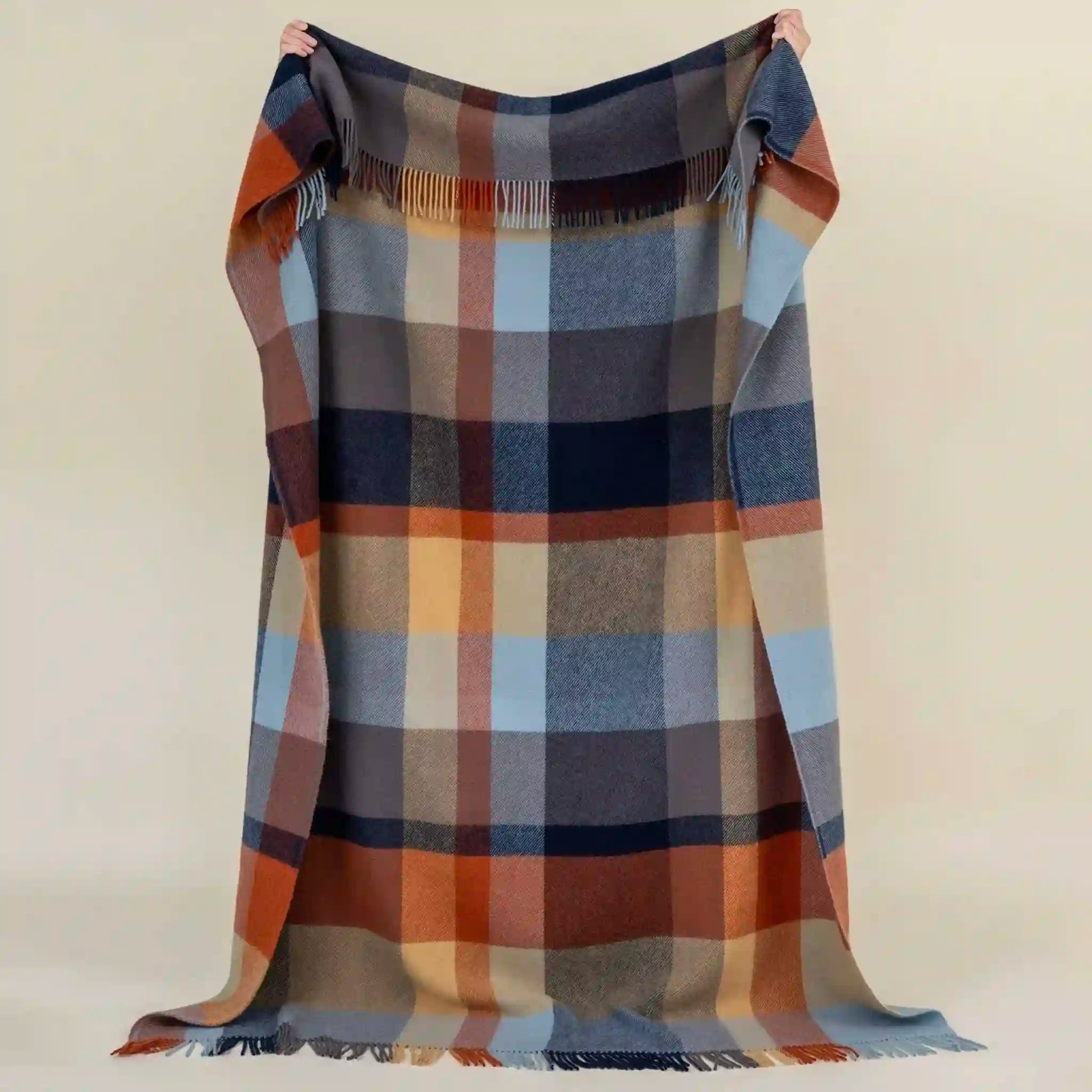 Plaid blanket with autumnal colors on a beige background