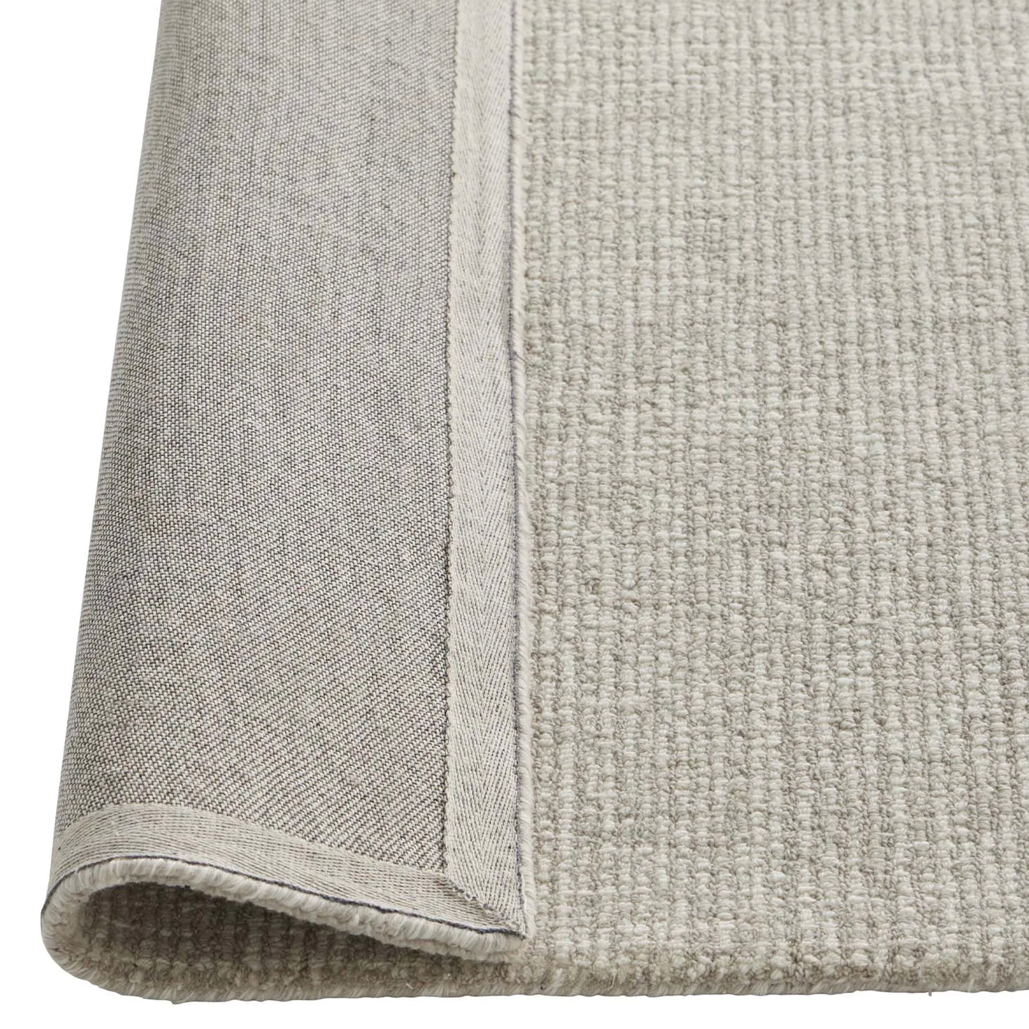Close-up of a textured gray rug corner