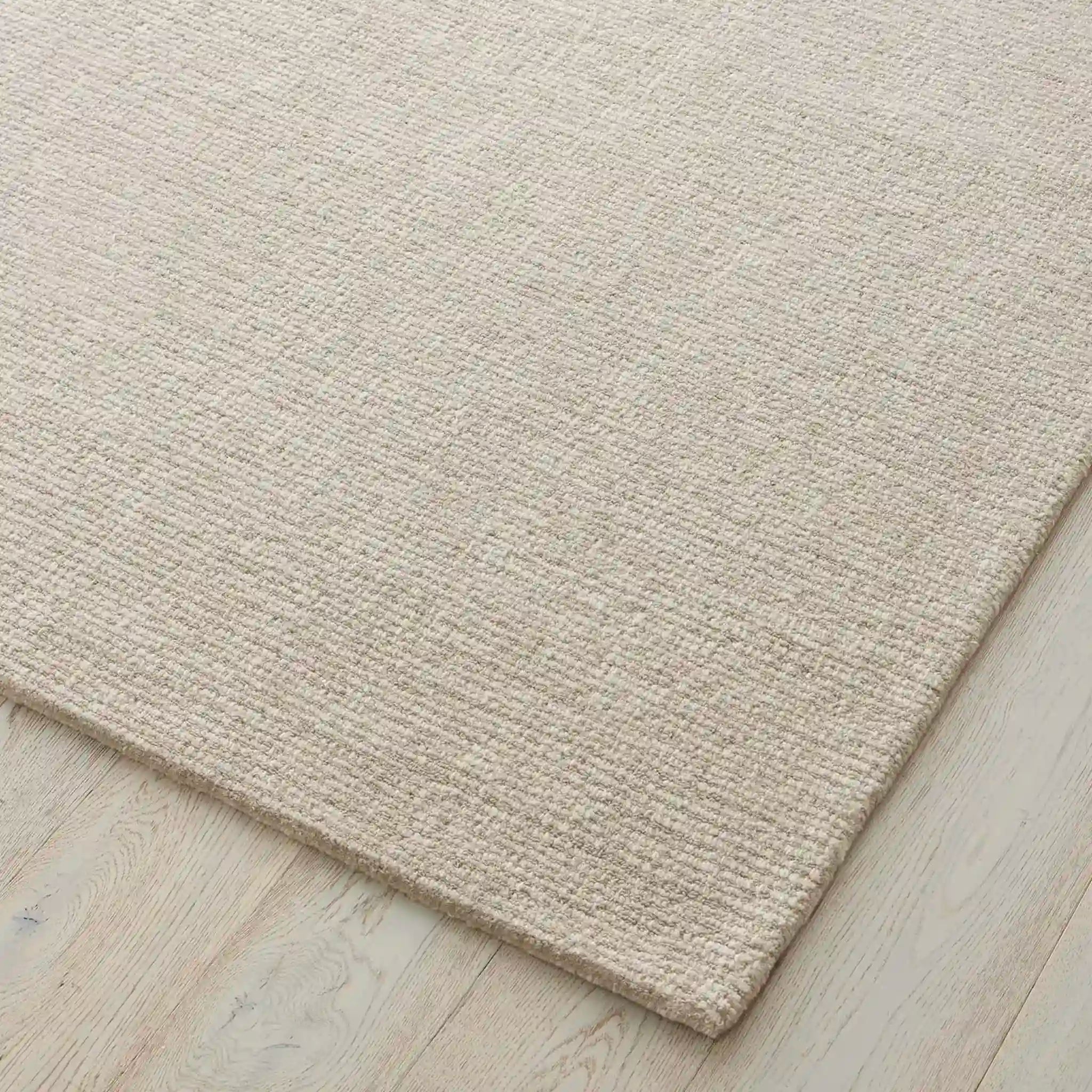 Beige rug on a wooden floor