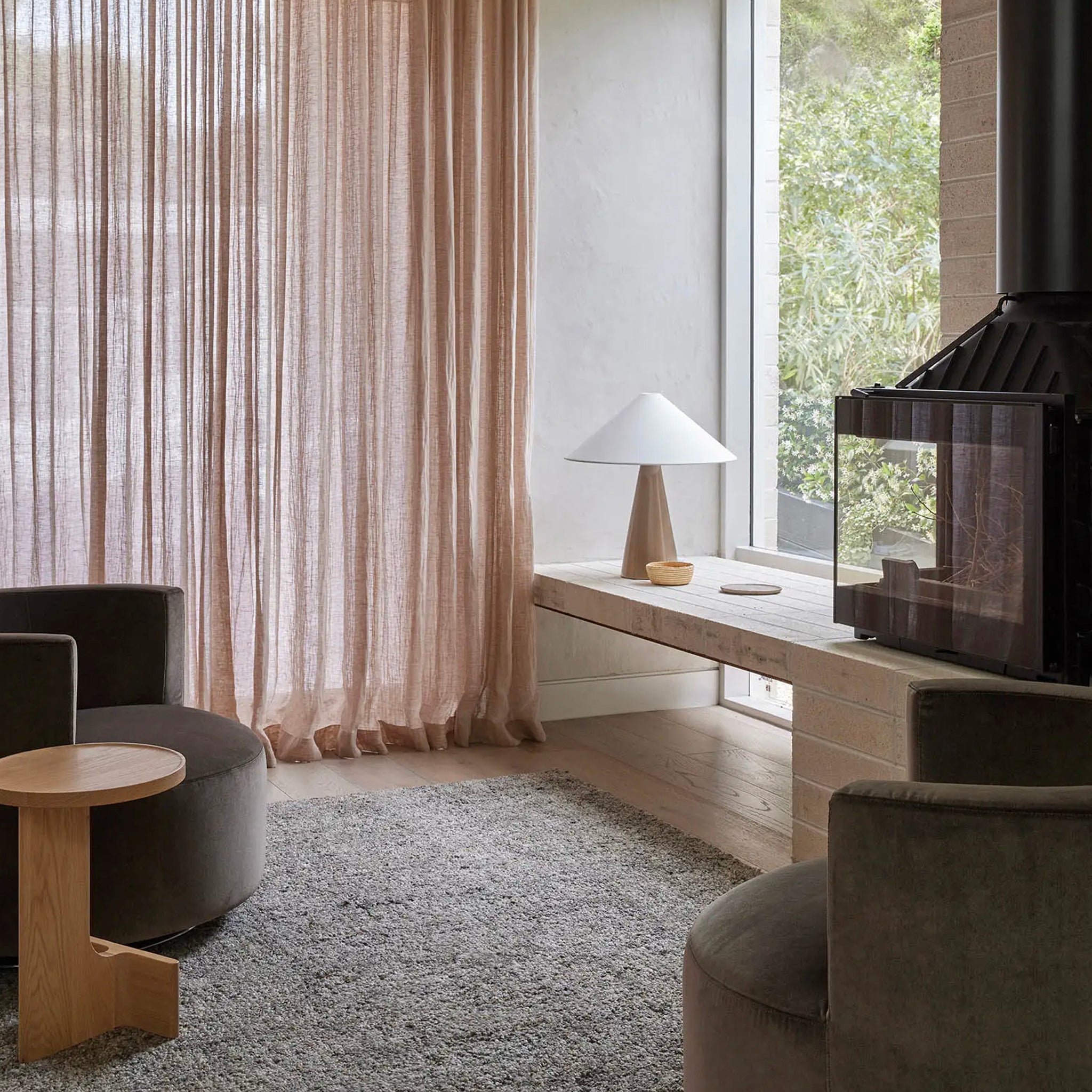 Modern living room with a fireplace, curtains, and furniture.