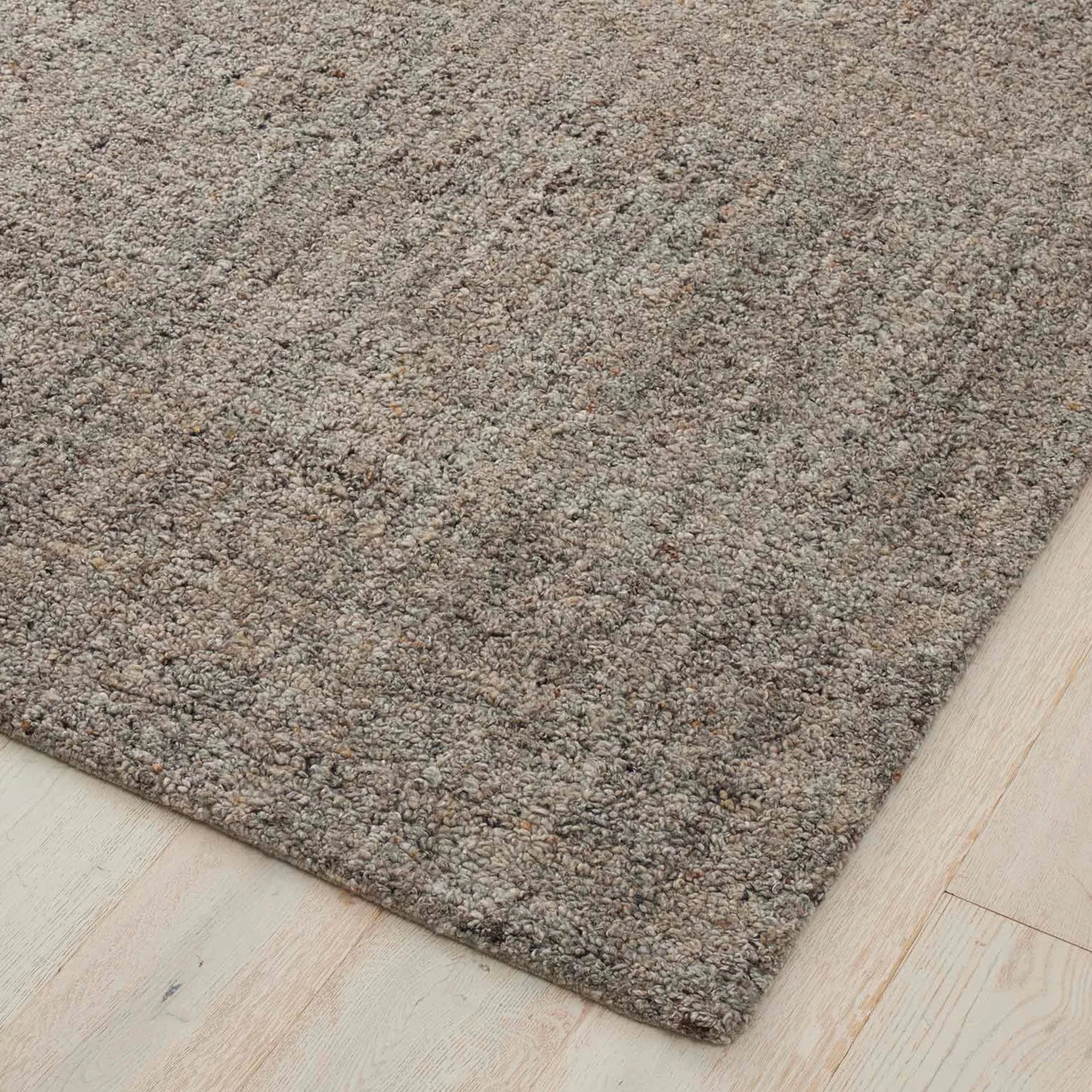 Close-up of a brown textured rug on a light wood floor