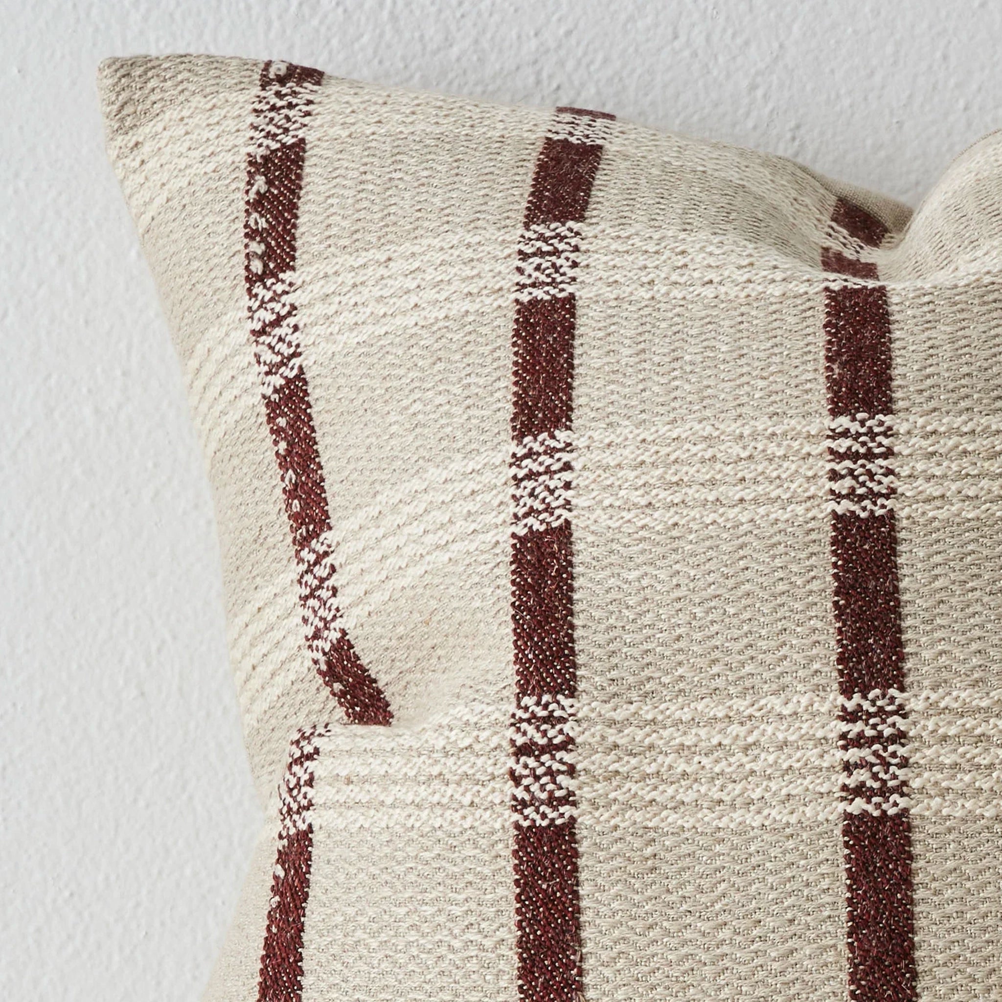 Textured pillow with brown and beige checkered pattern on a white background