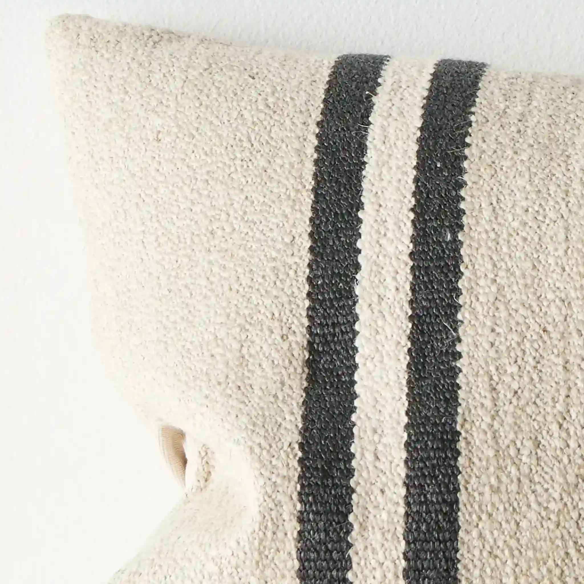 Textured cushion with black stripes on a white background