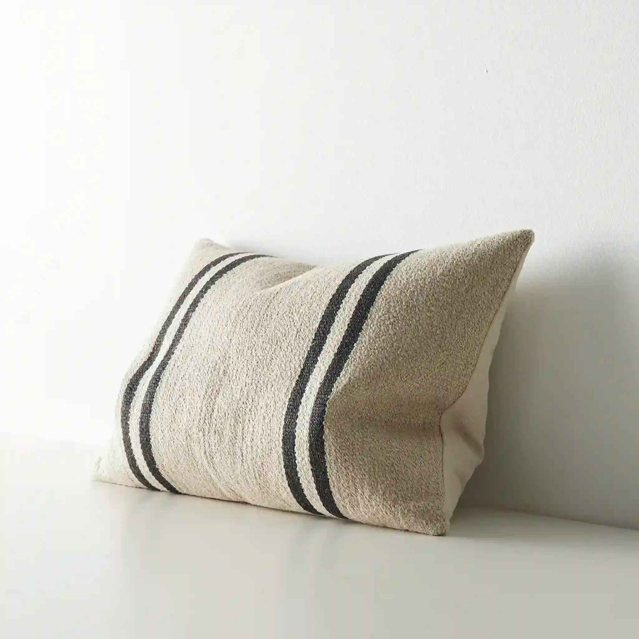 Textured cushion with black stripes on a white background