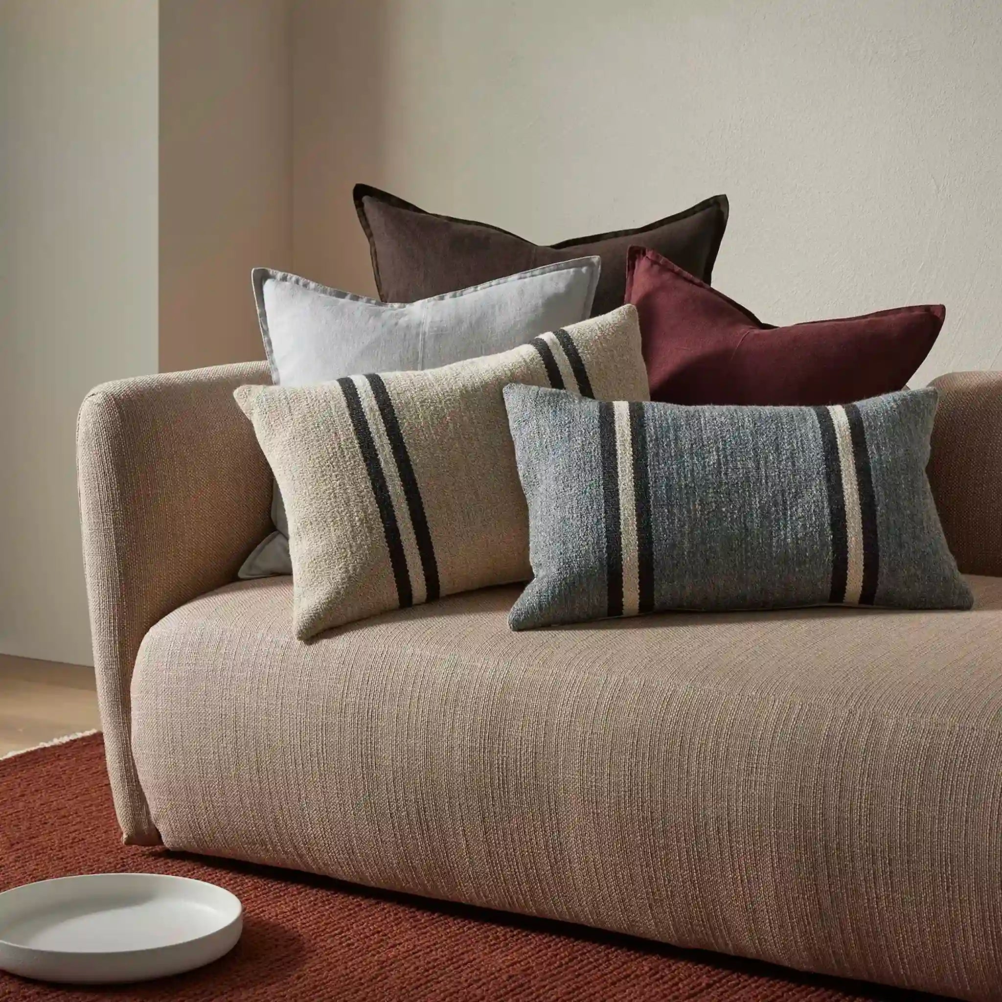 Decorative cushions on a beige sofa with a neutral background