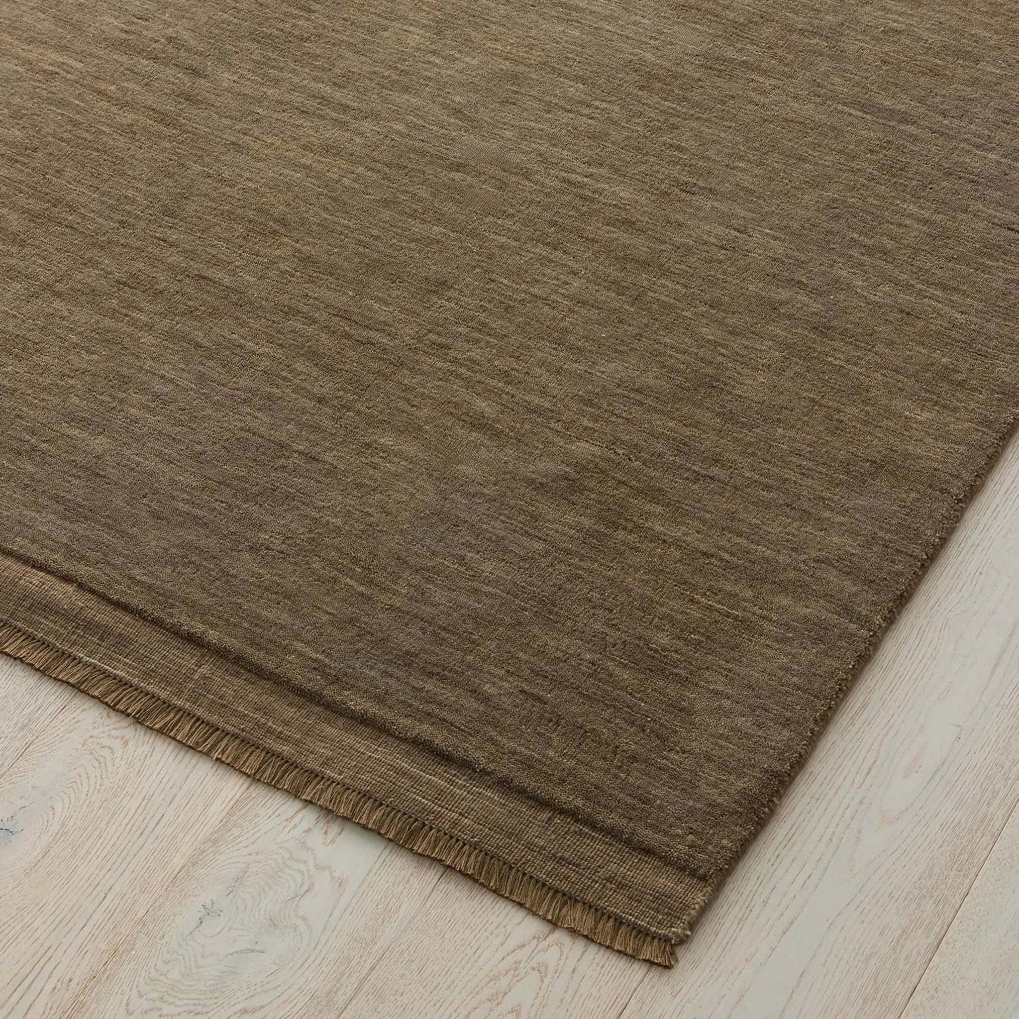 Brown rug on a wooden floor.