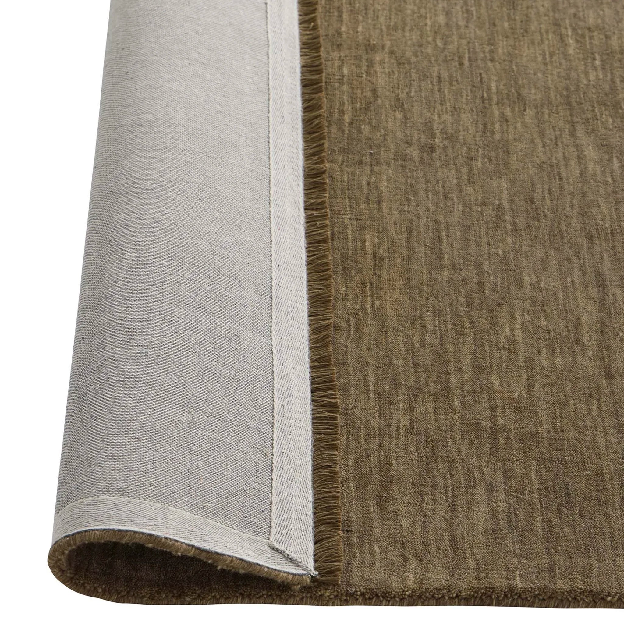 Close-up of a brown and gray rug corner with frayed edges.