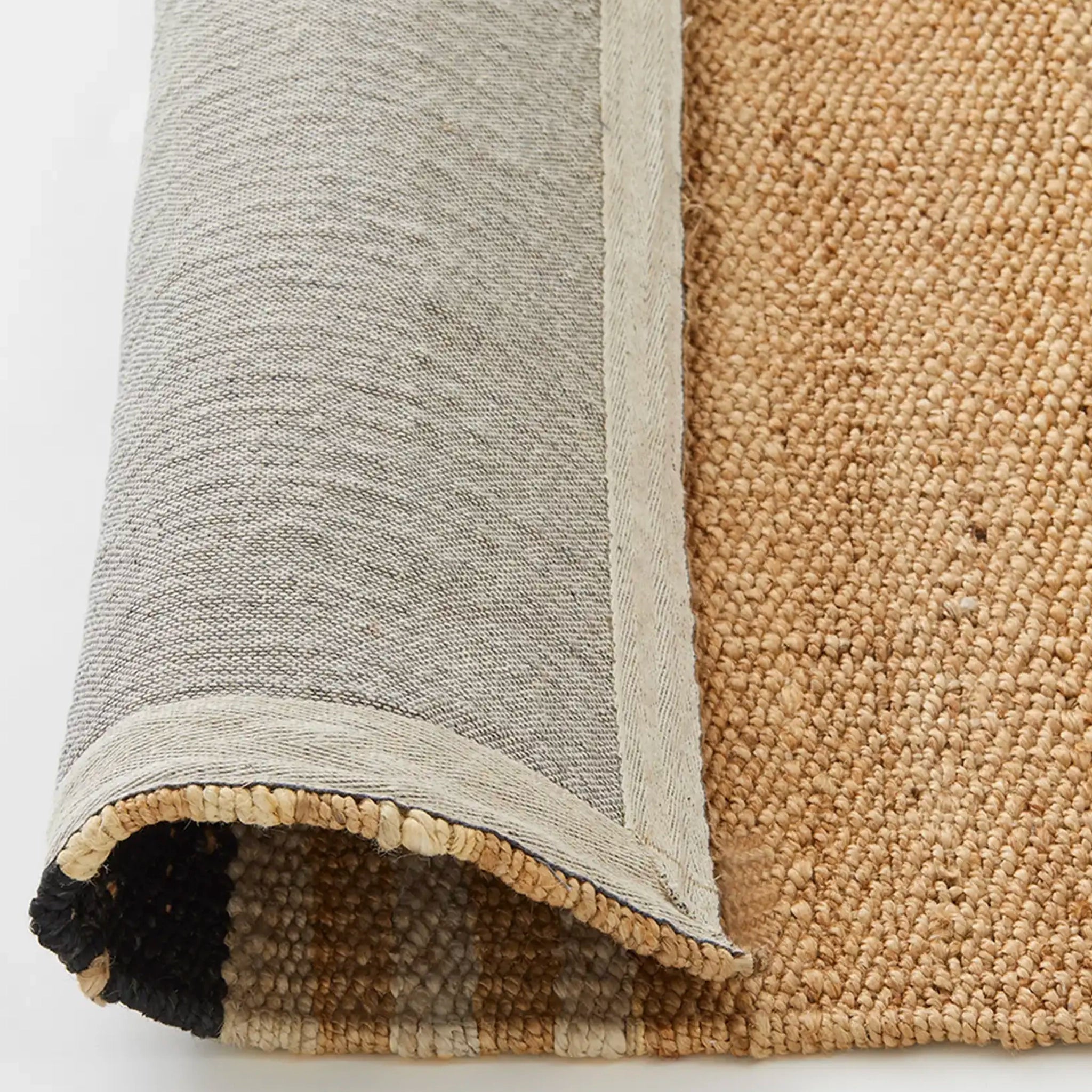 Close-up of a textured rug with a gradient from gray to beige.
