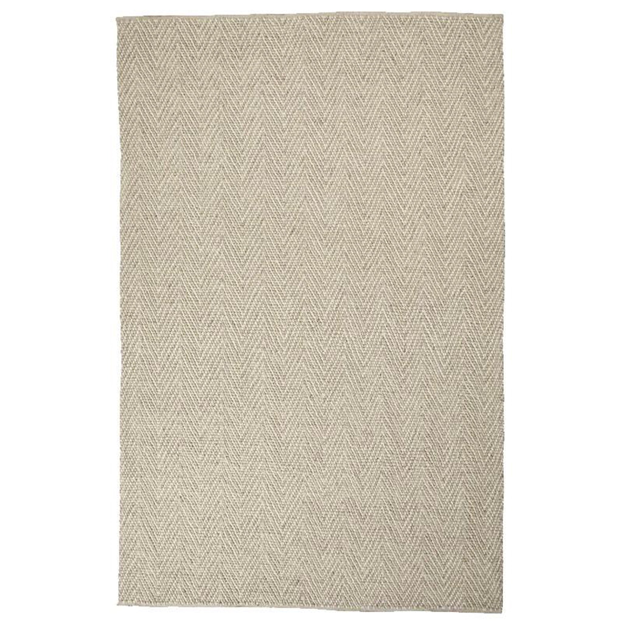 Beige and white geometric patterned rug on a white background