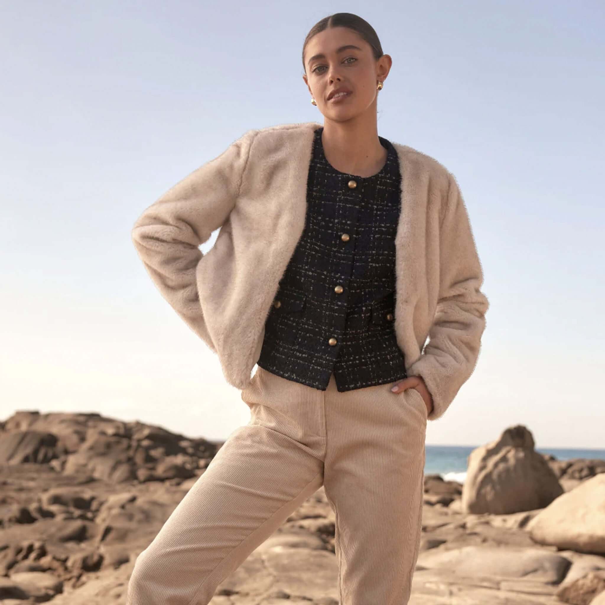 Alt Tag: Zoe Kratzmann Dune Jacket - Ecru plush faux fur cropped jacket styled over textured top with neutral pants outdoors