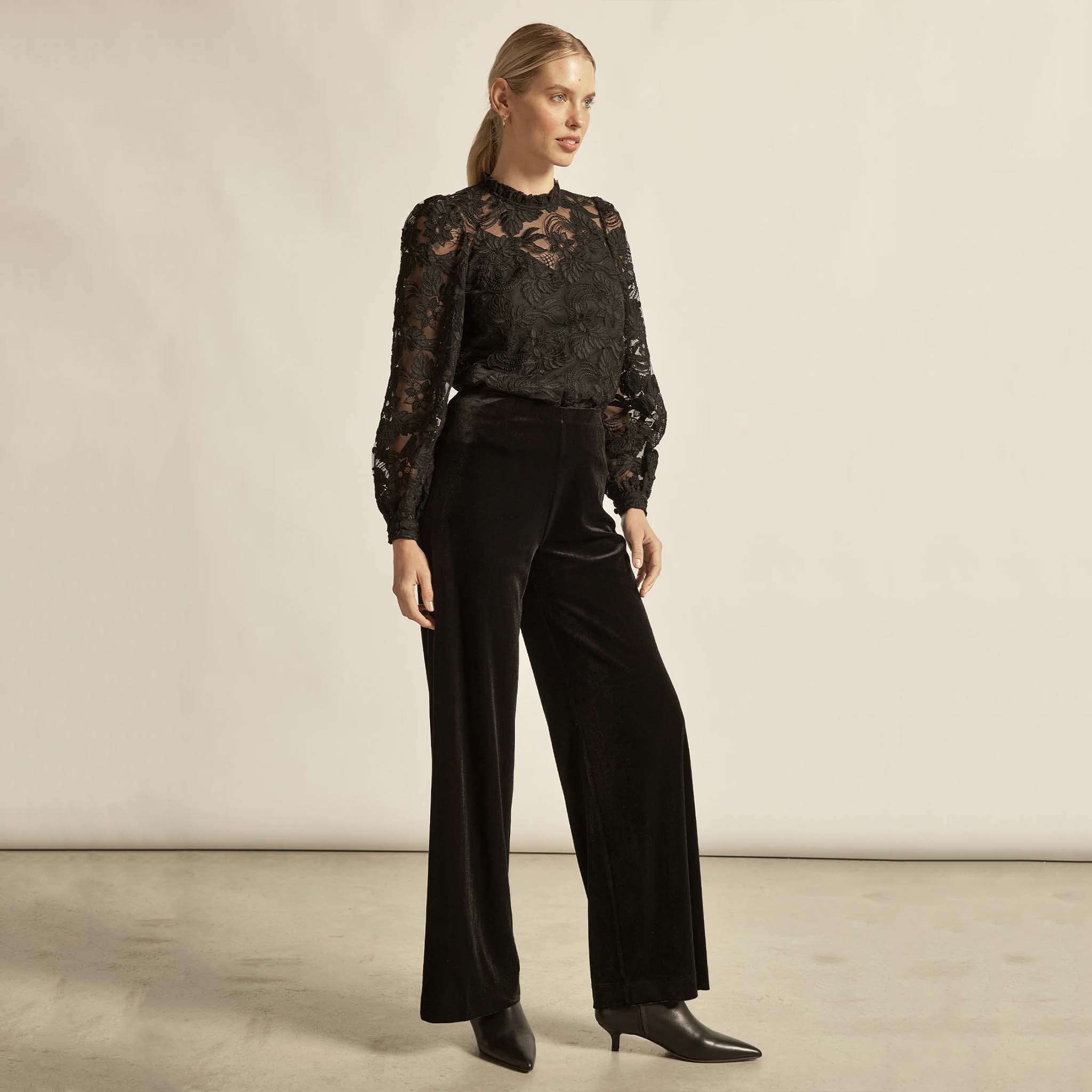 Alt Tag: Zoe Kratzmann Glint Top - Black lace long sleeve frill neck top styled with black wide-leg pants and ankle boots