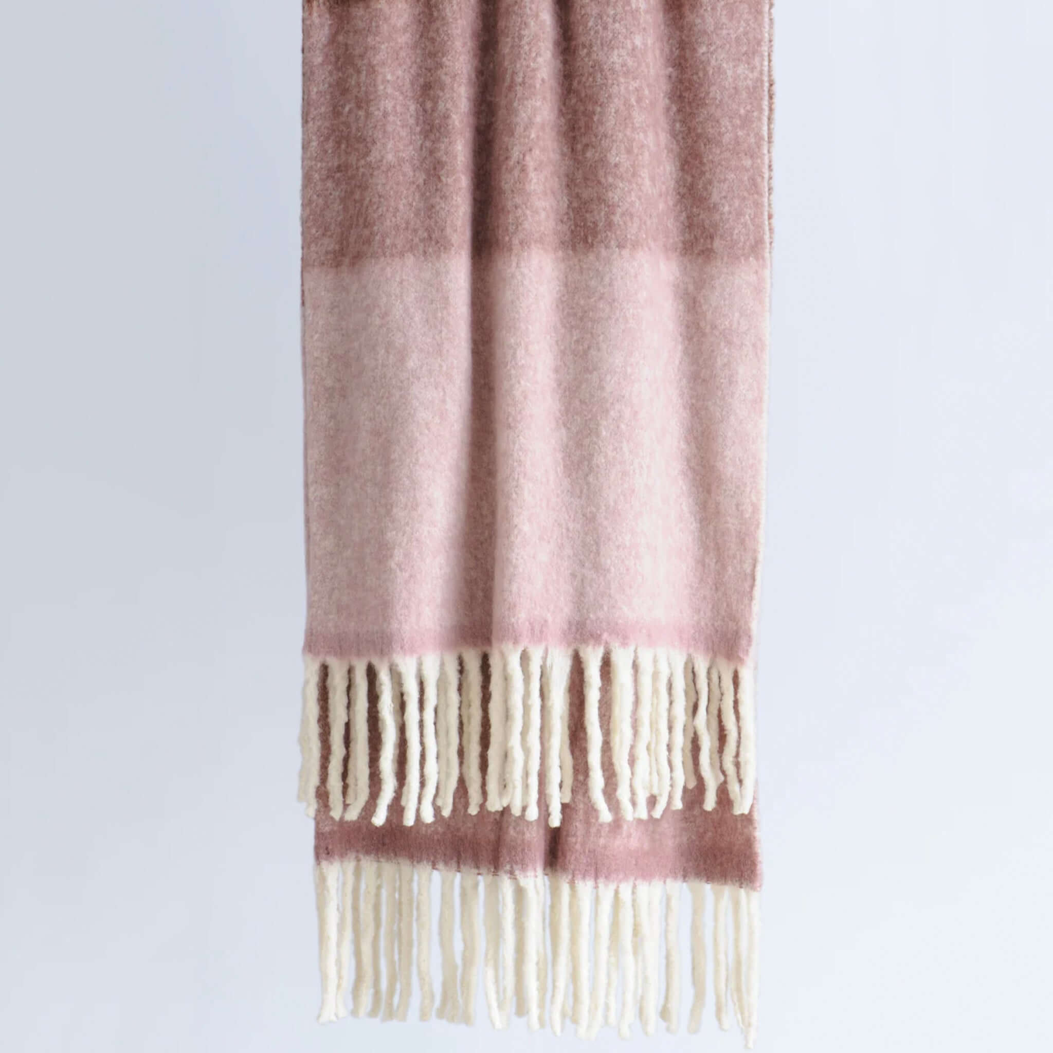 Bianca Lorenne Arundel Throw - Plum Blossom hanging with soft colors and chunky tassels, perfect for cozy decor.