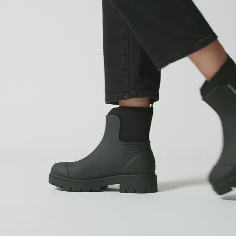 Alt Tag: Merry People Tully Boots - Black worn with black jeans, waterproof vegan rubber gumboots with chunky platform sole and neoprene cuff